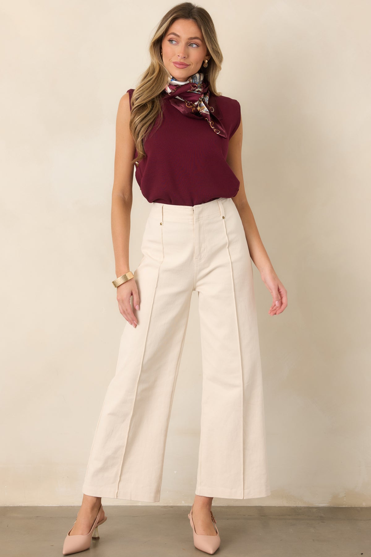 Lightweight sweater knit top featuring a clean crew neckline, relaxed sleeveless silhouette, smooth drape, and functional gold-tone buttons along the side.
