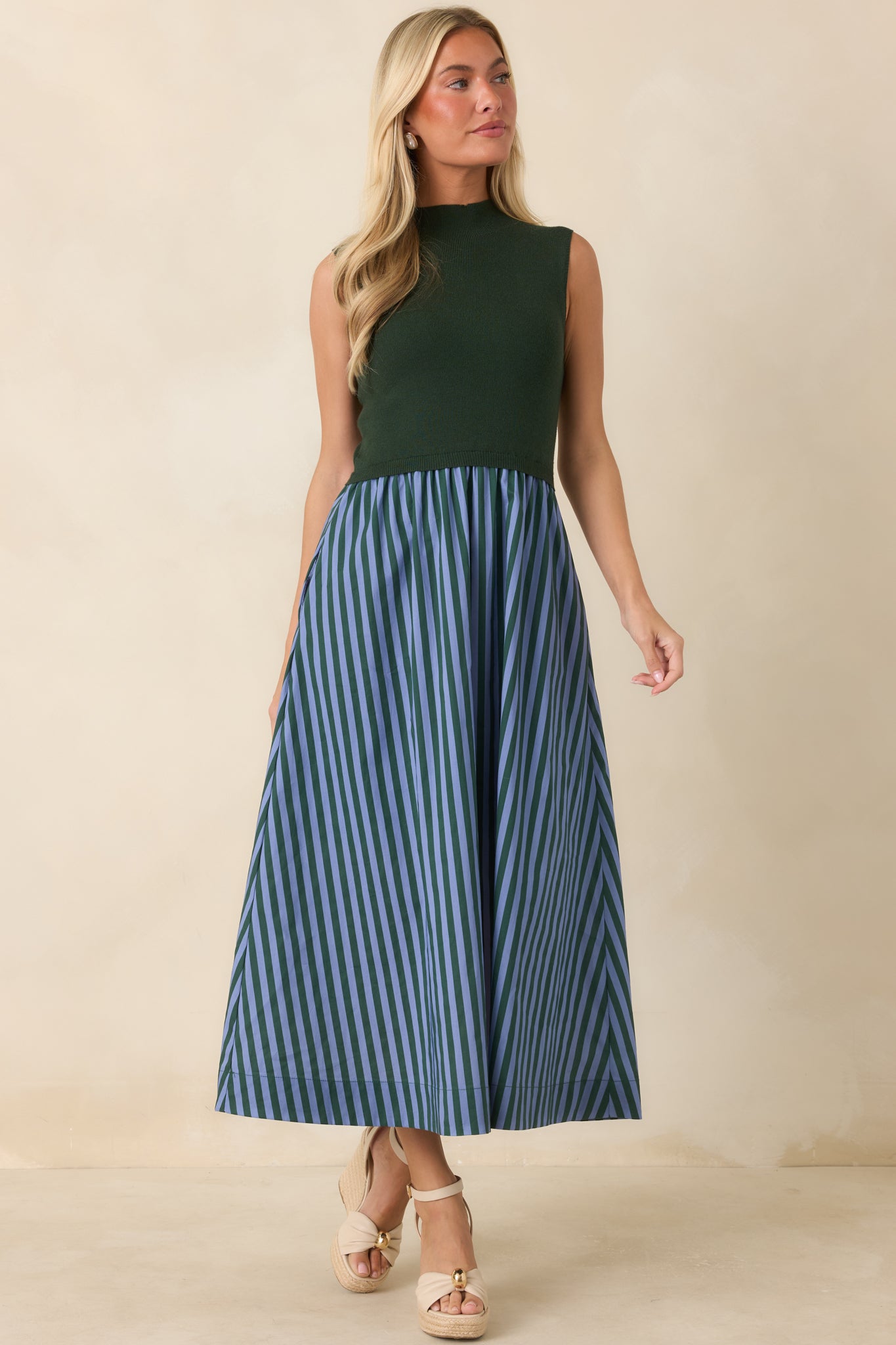 Sleeveless knit midi dress with a polished mock neck, textured design, and flowing full skirt accented with classic stripes.