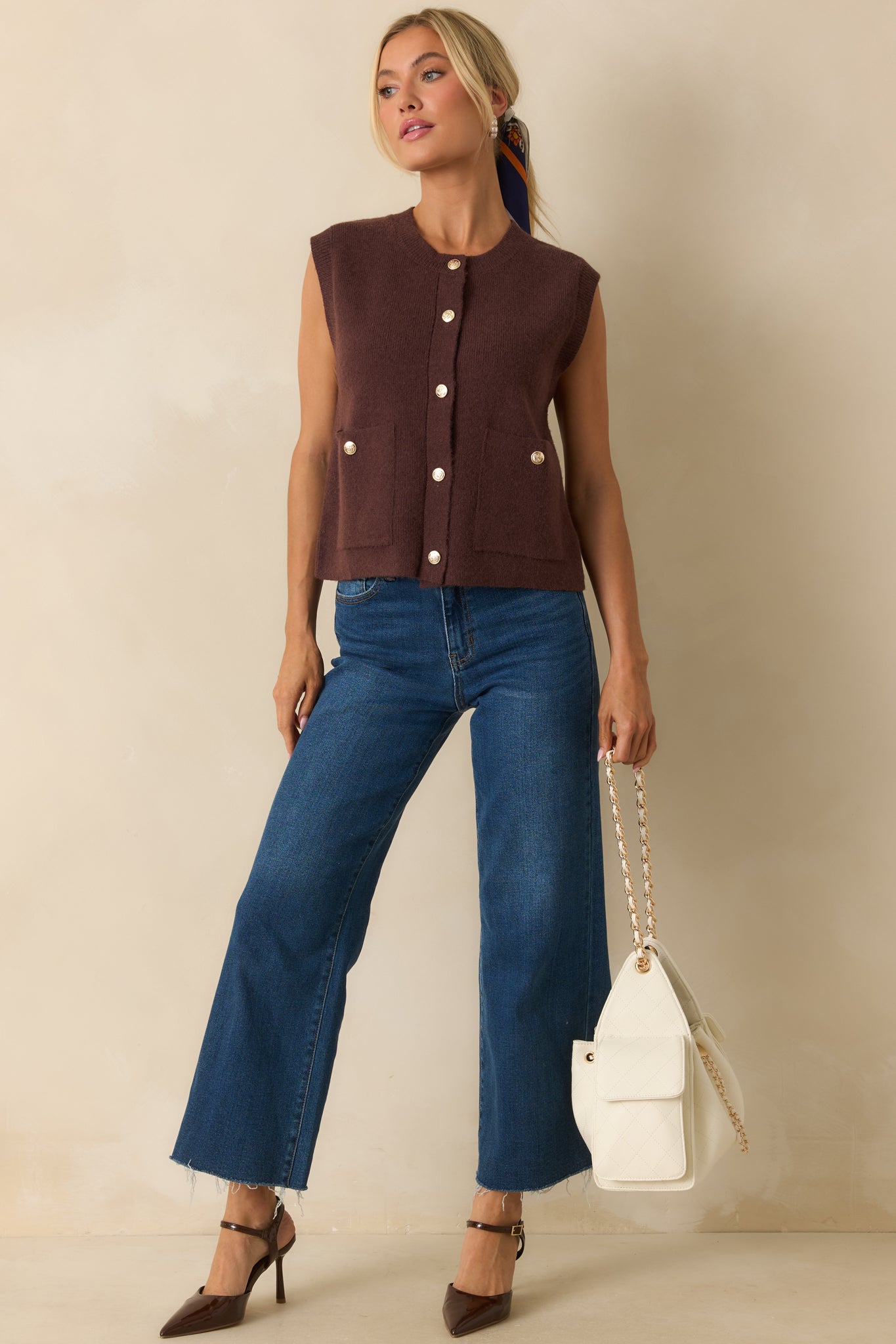 Sleeveless knit vest with a crew neckline and front button closures for a relaxed, polished look.