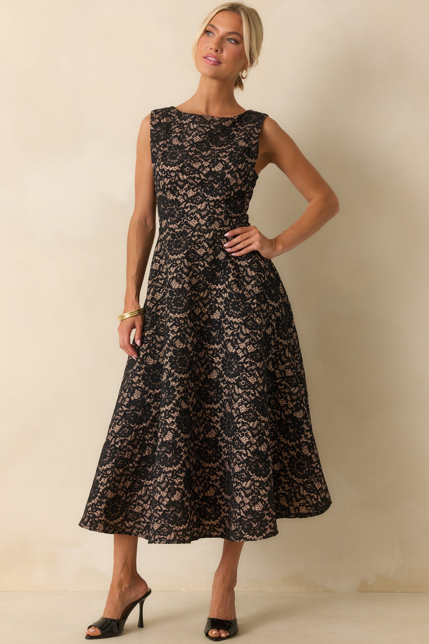 Sleeveless lace overlay midi dress with a cinched waist and soft floral pattern throughout.
