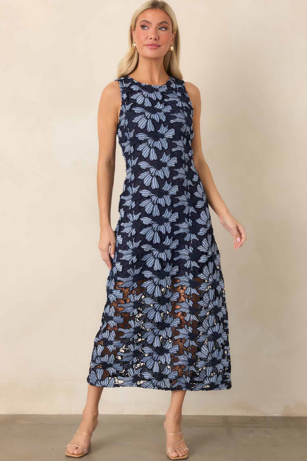 Sleeveless floral dress showcasing oversized light blue blooms, a rounded neckline, and airy lace extending below the lining.