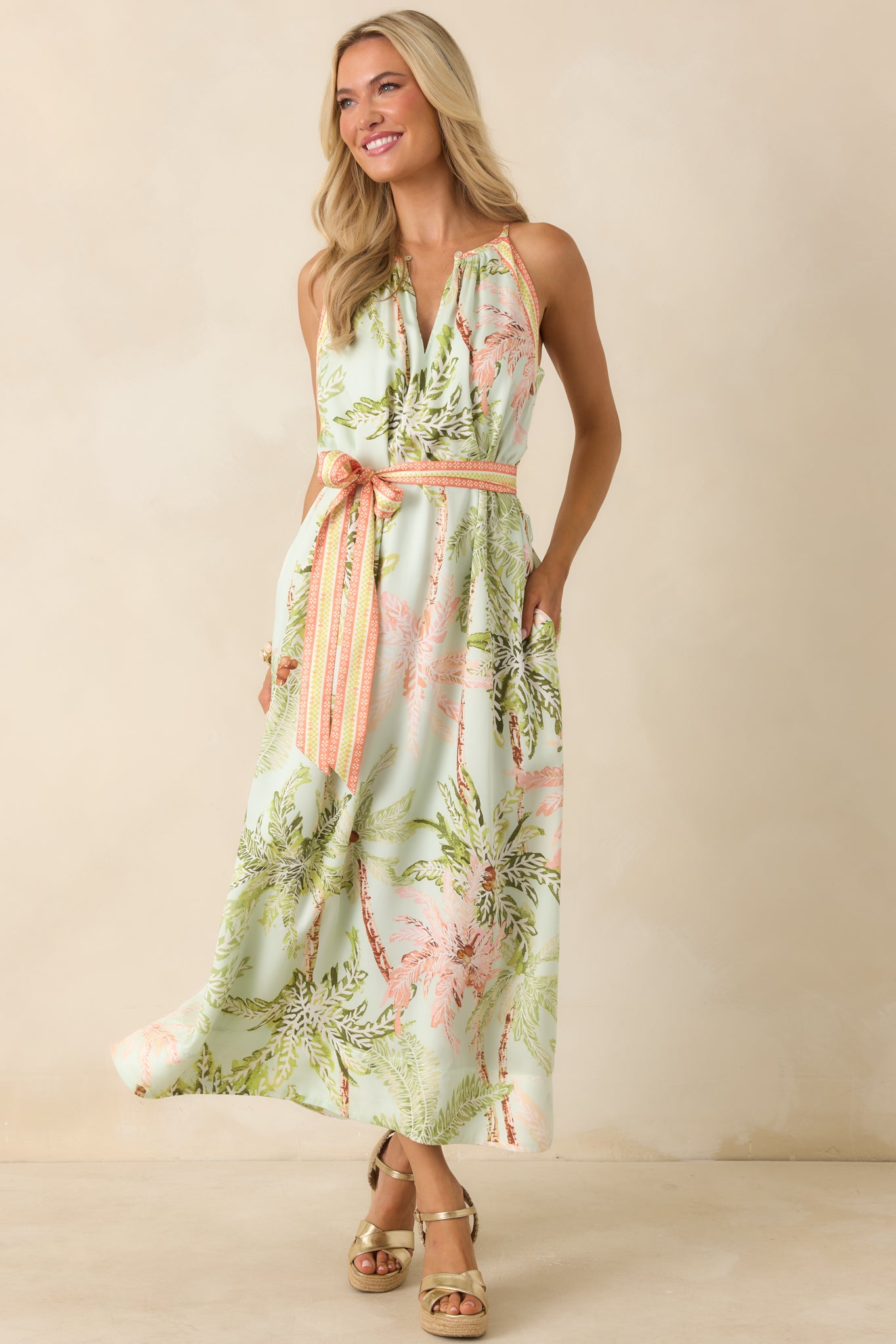 Sleeveless maxi dress showcasing a relaxed, flowing silhouette with a front keyhole detail and coordinated self-tie sash at the waist.