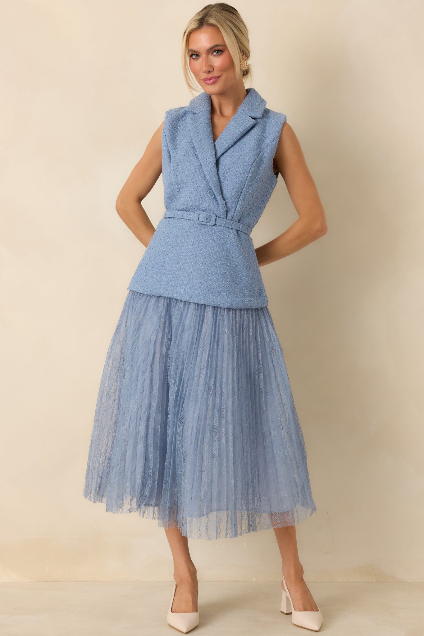 Sleeveless midi dress in textured blue fabric with defined waist and soft pleated lace detailing.