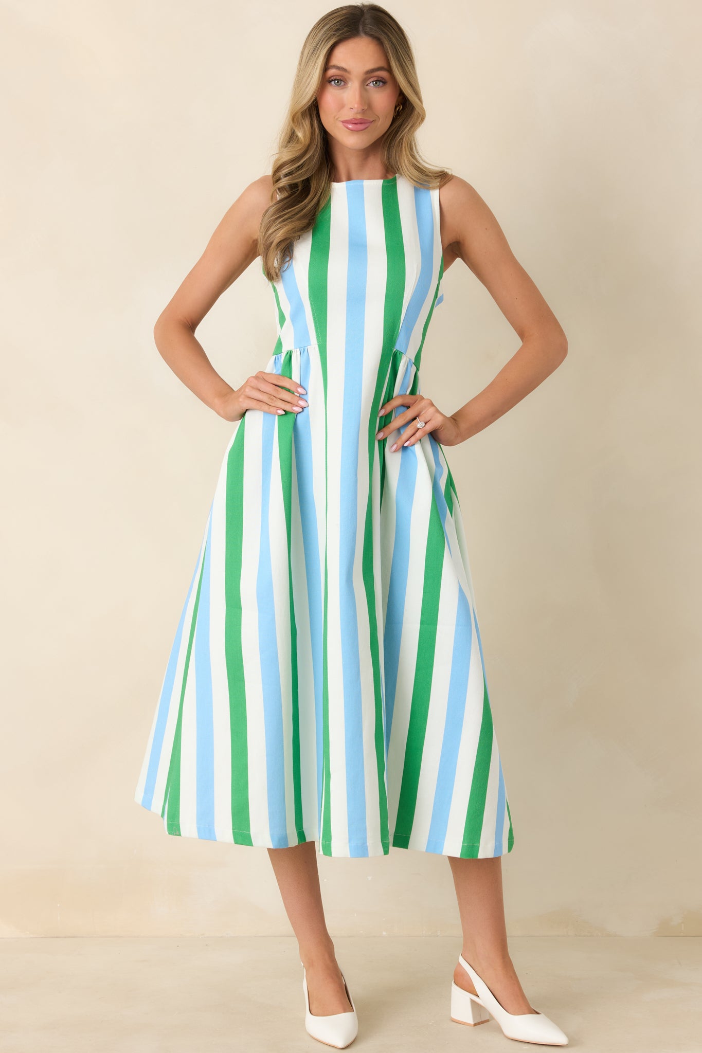 Front view of a sleeveless midi dress with vertical stripe pattern, fitted bodice, and added skirt volume.