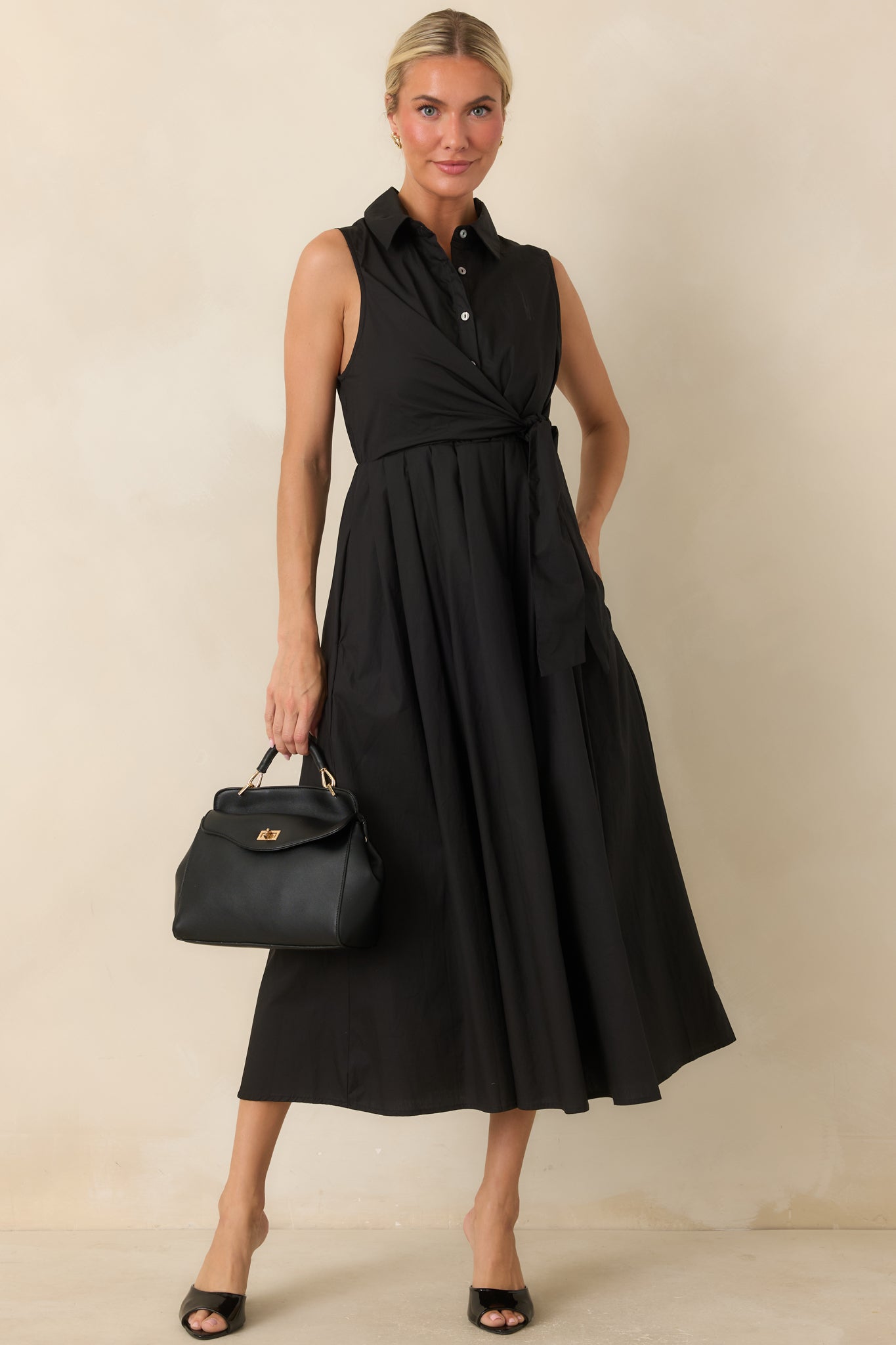 Sleeveless midi dress designed with a polished collar, flowing skirt, and comfortable hidden side pockets.