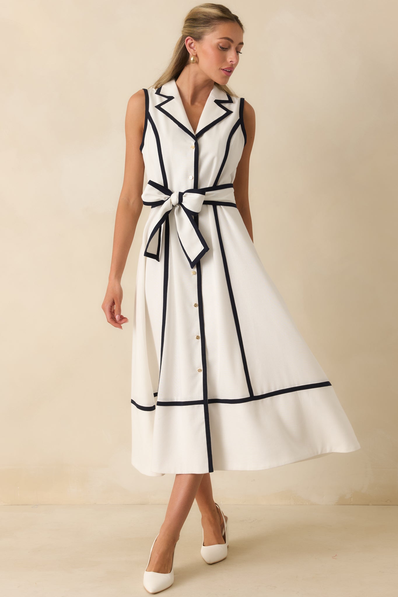 Sleeveless midi dress featuring a full skirt, tailored bodice, and contrast piping that highlights the silhouette.