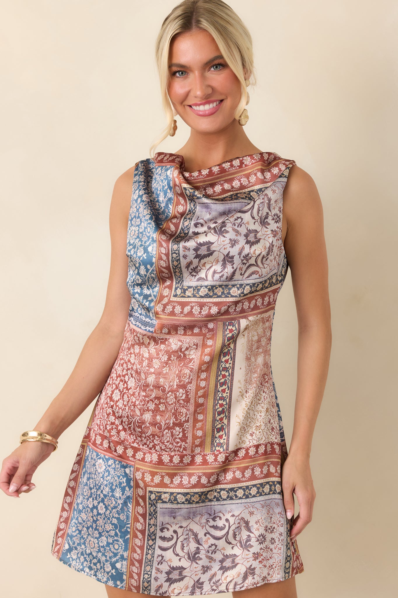 The sleeveless design and elegant cowl neckline create a timeless look on this mini dress.