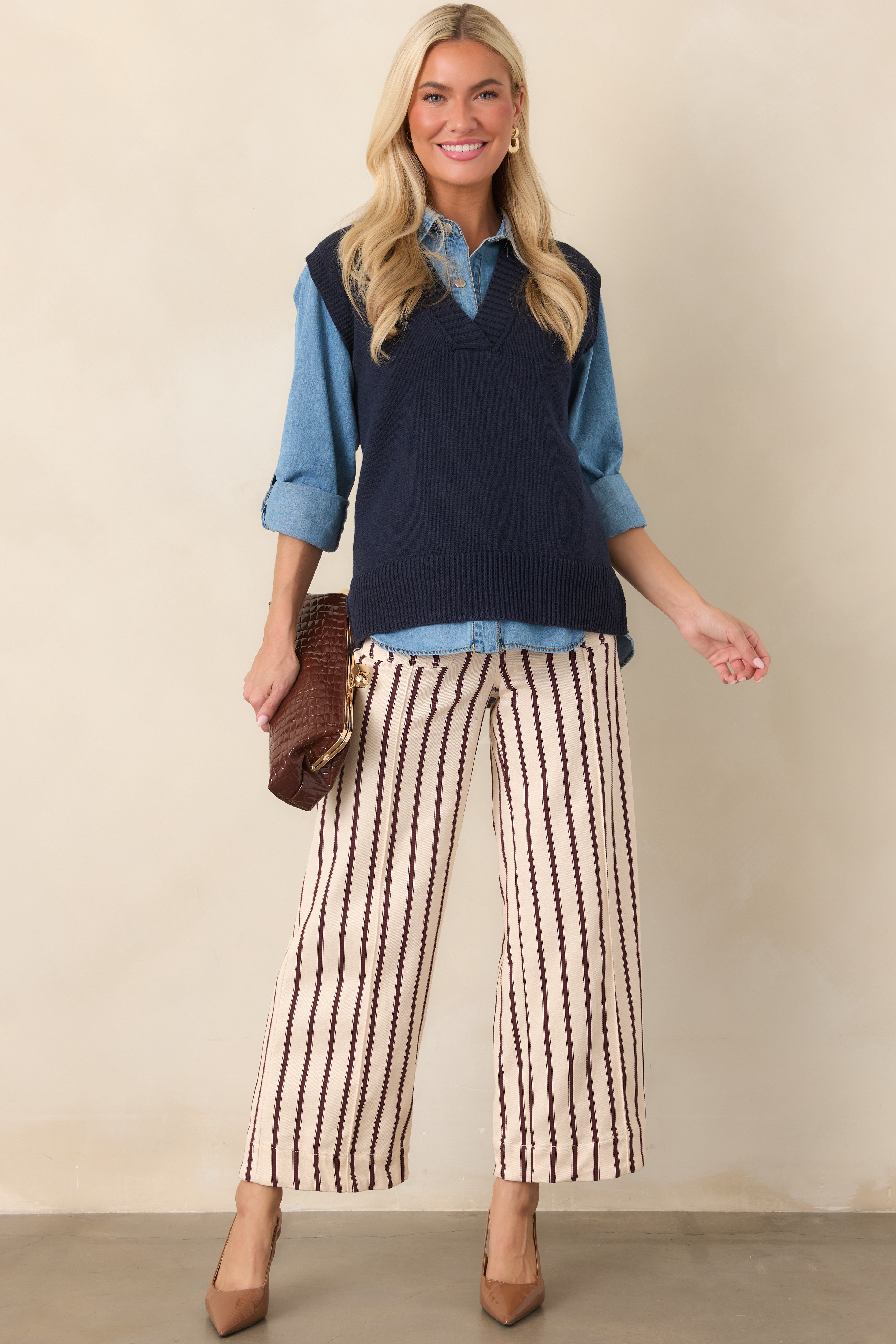 Sleeveless navy knit vest showcasing a relaxed fit, textured ribbed neckline, and wide ribbed hem with a softly structured shape.