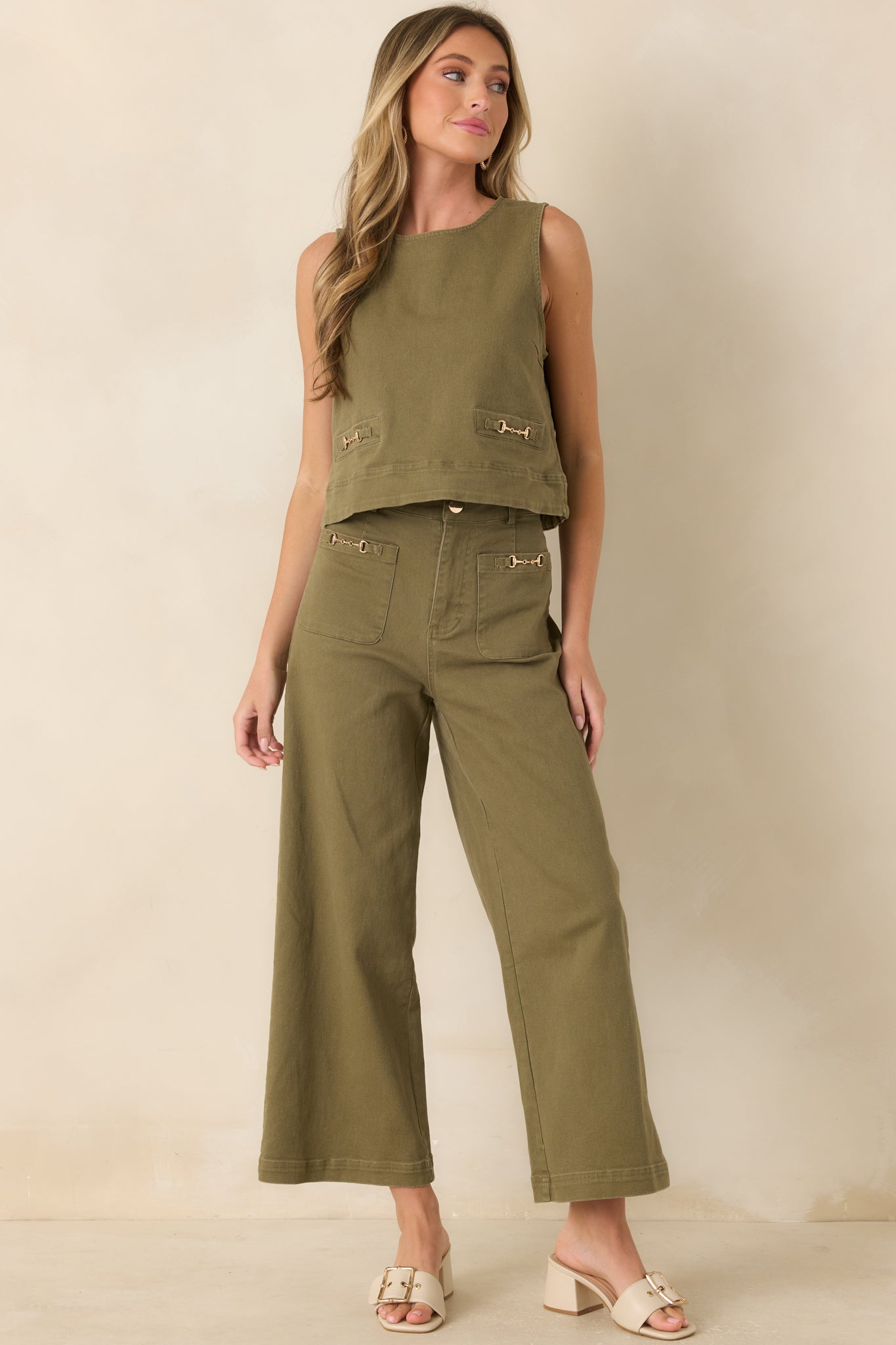 Sleeveless olive top showcasing a clean round neckline, stretch denim fabric, and polished hardware.