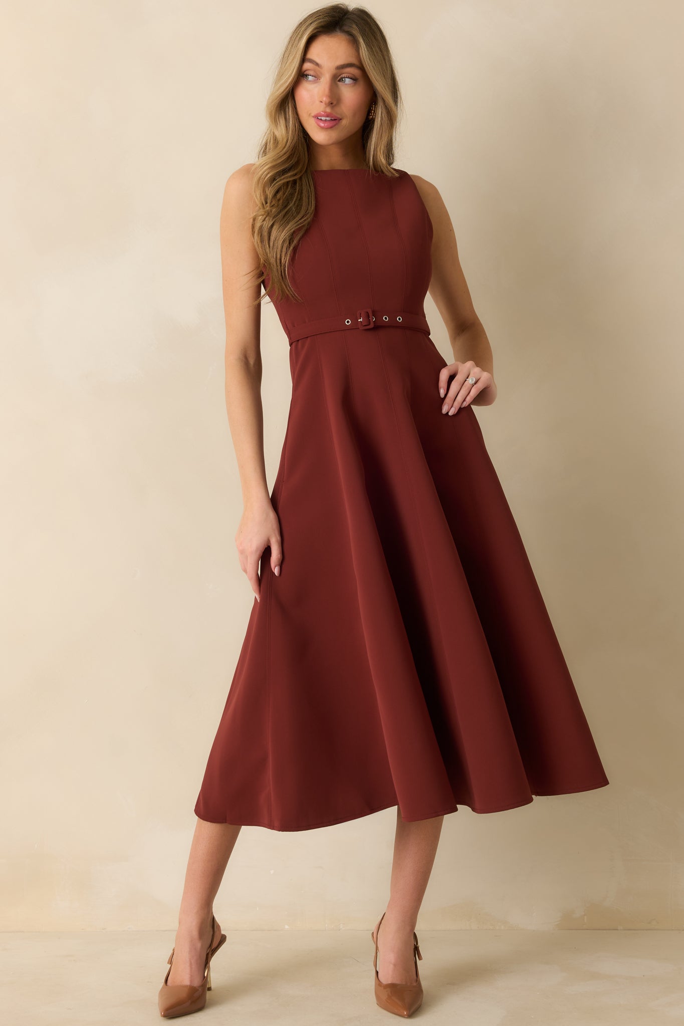 Sleeveless red midi dress with structured seaming and flowing A-line hem.