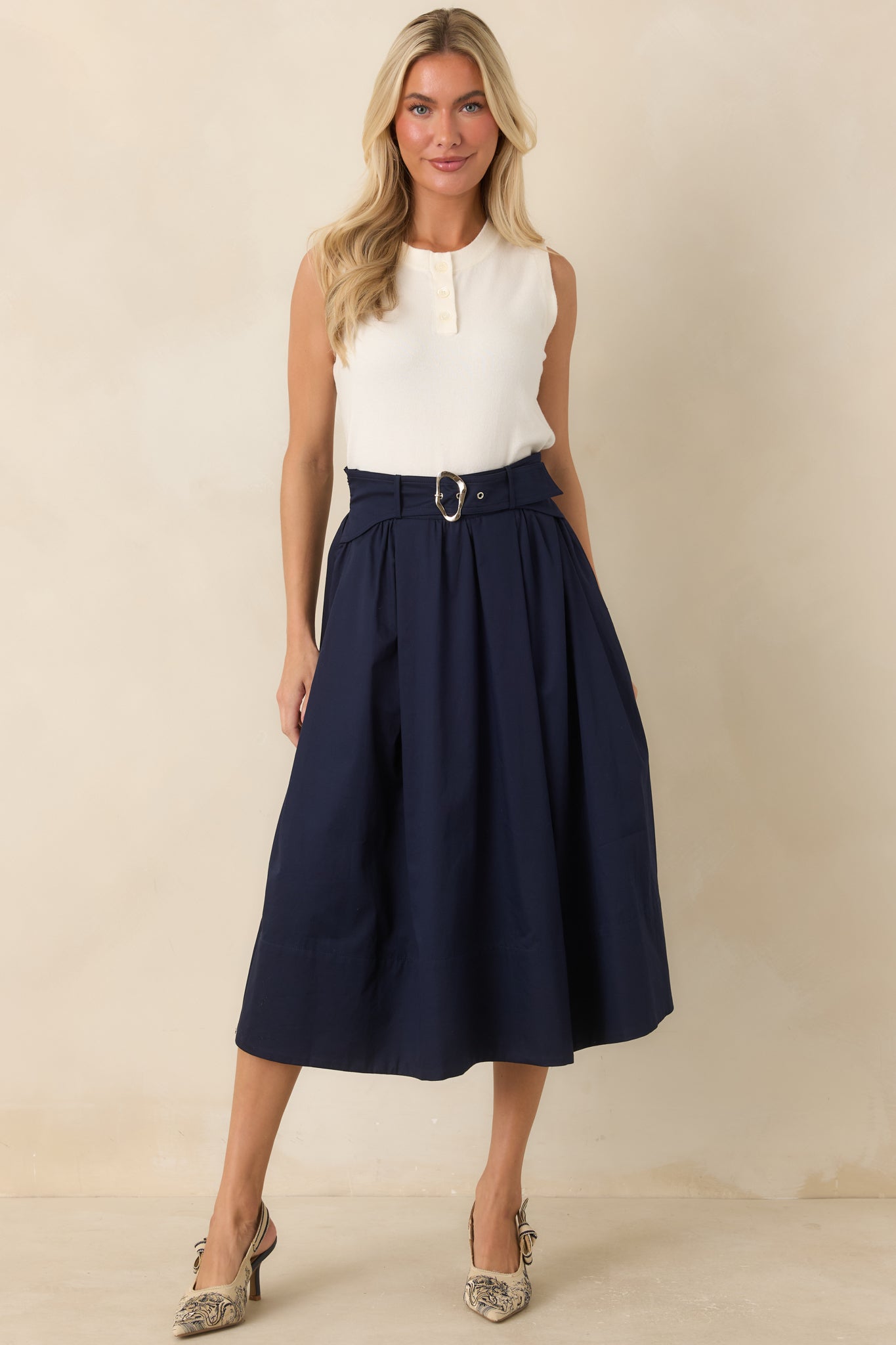 Sleeveless sweater crafted from a soft knit blend, showcasing a lightweight feel and refined button-front detailing at the neckline.
