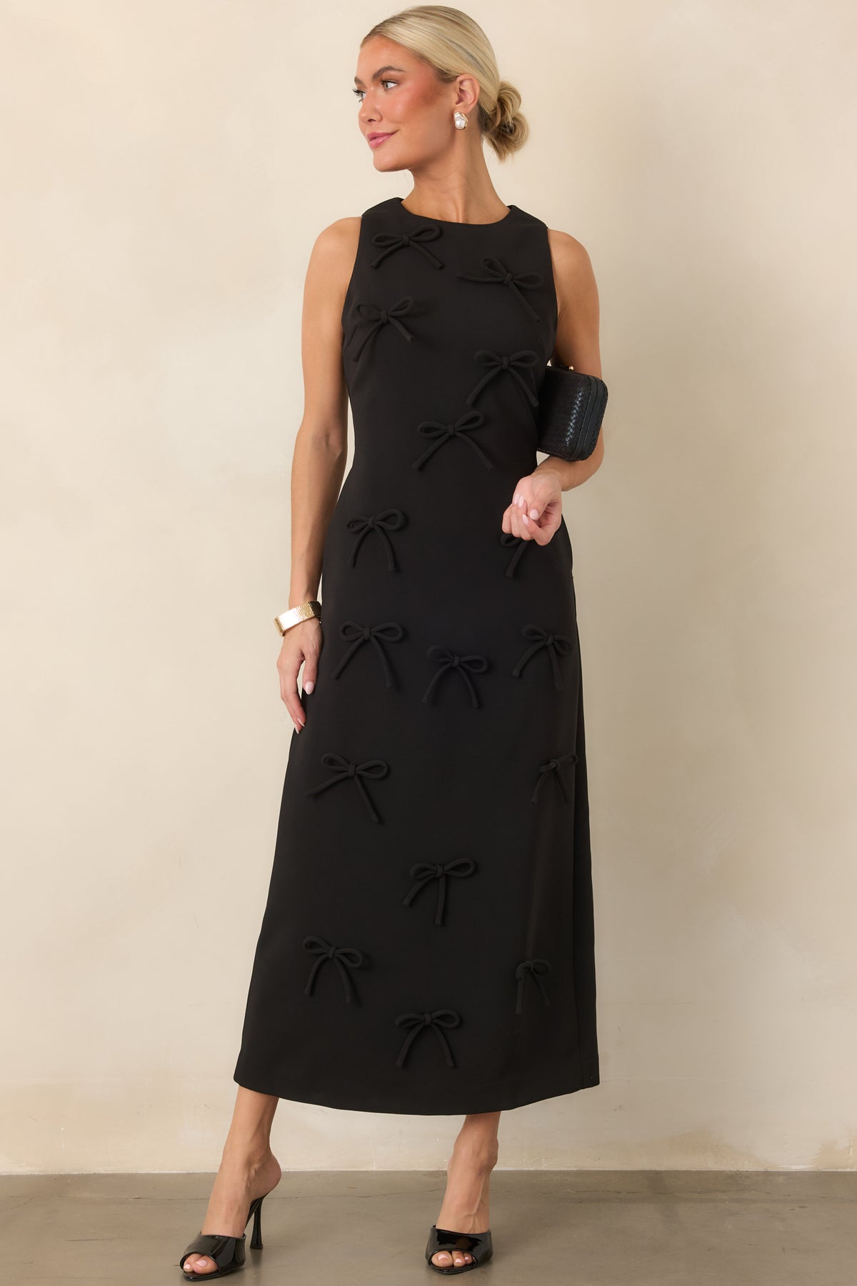 Fitted column-style maxi showcasing an all-over arrangement of raised tonal bows and a sleek sleeveless design.