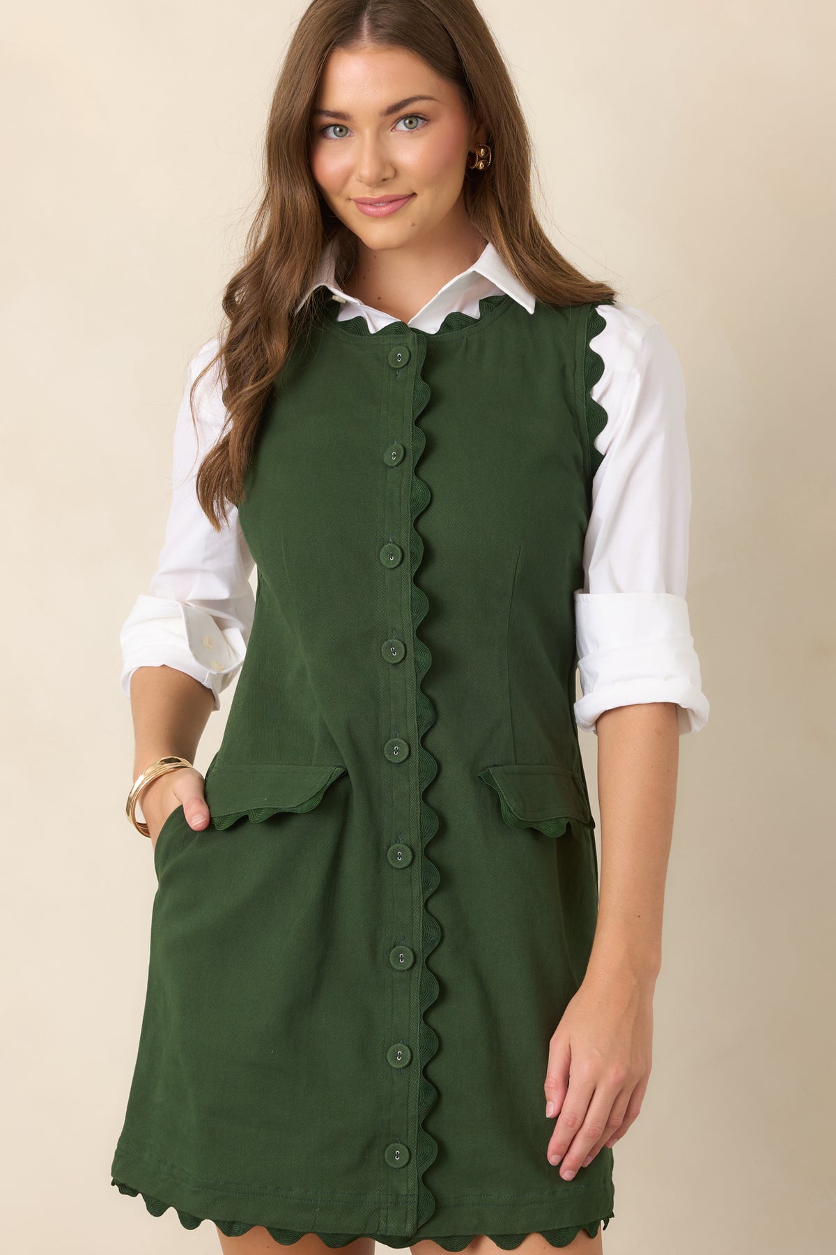 Sleeveless mini silhouette featuring delicate tonal ric rac trim, a structured button placket, and shaping through the waist.