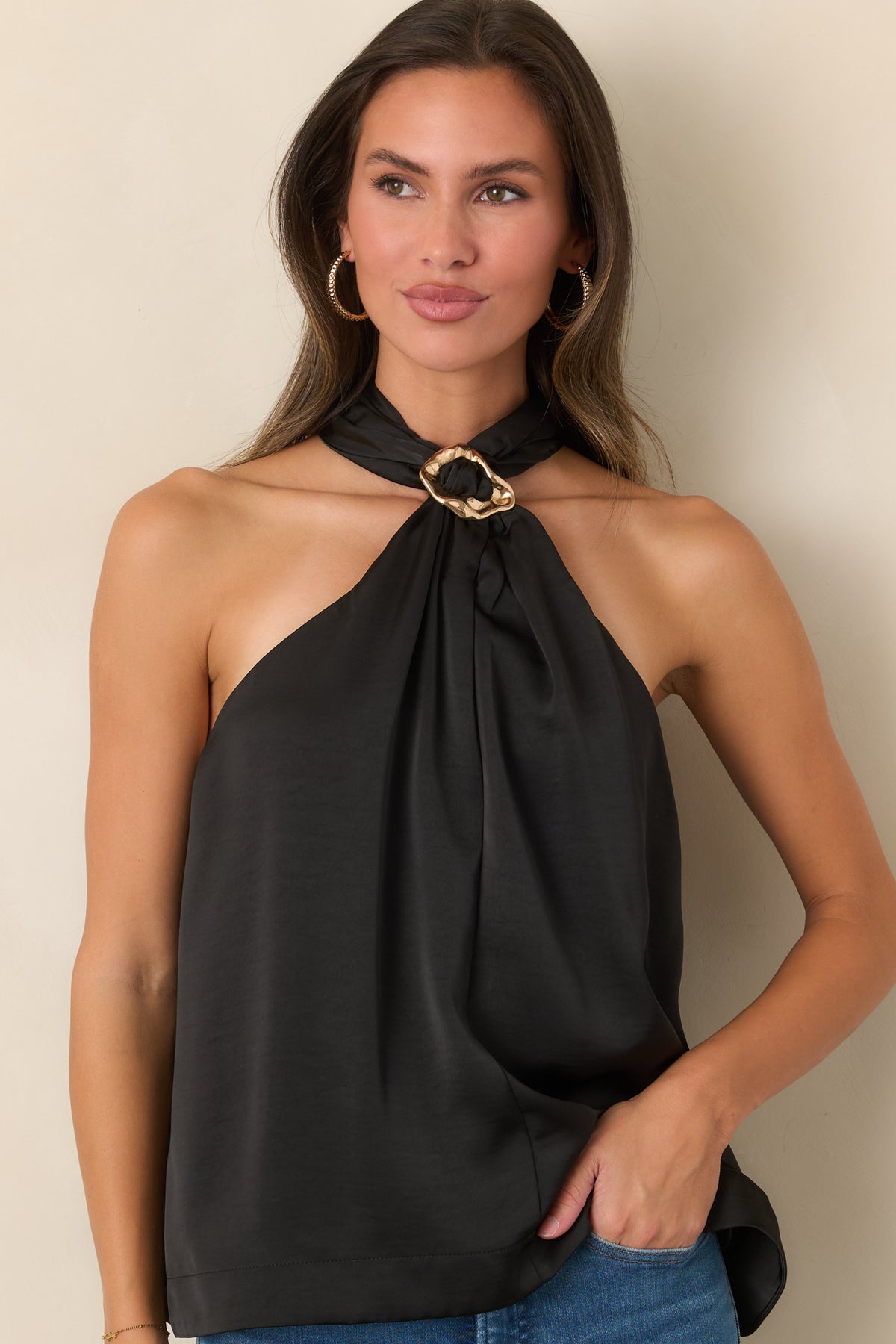 Sleeveless top highlights the statement ring accent at the neckline against its streamlined silhouette.