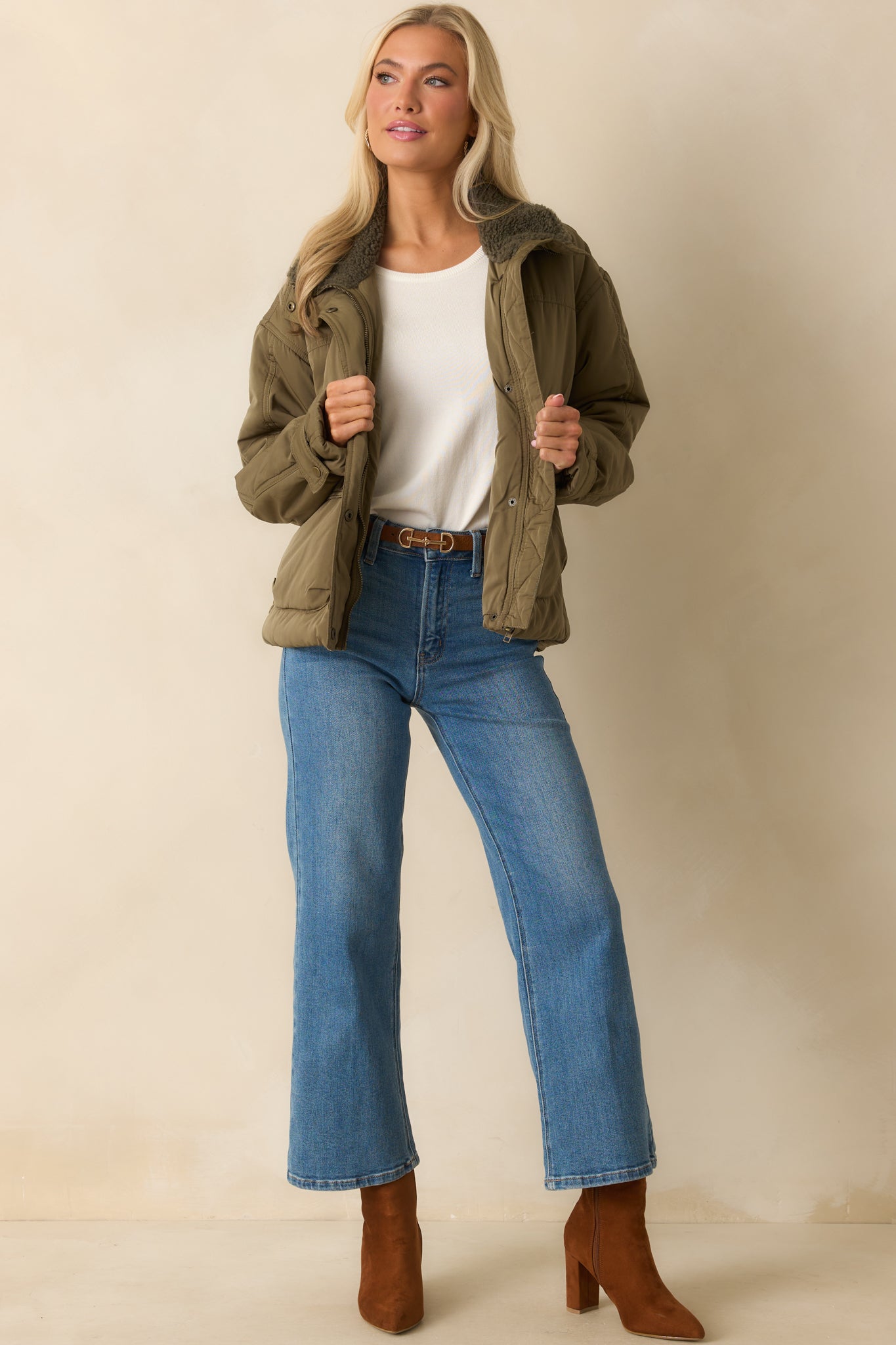 Slightly boxy army green jacket with front closure, sherpa collar, and cozy quilted texture.