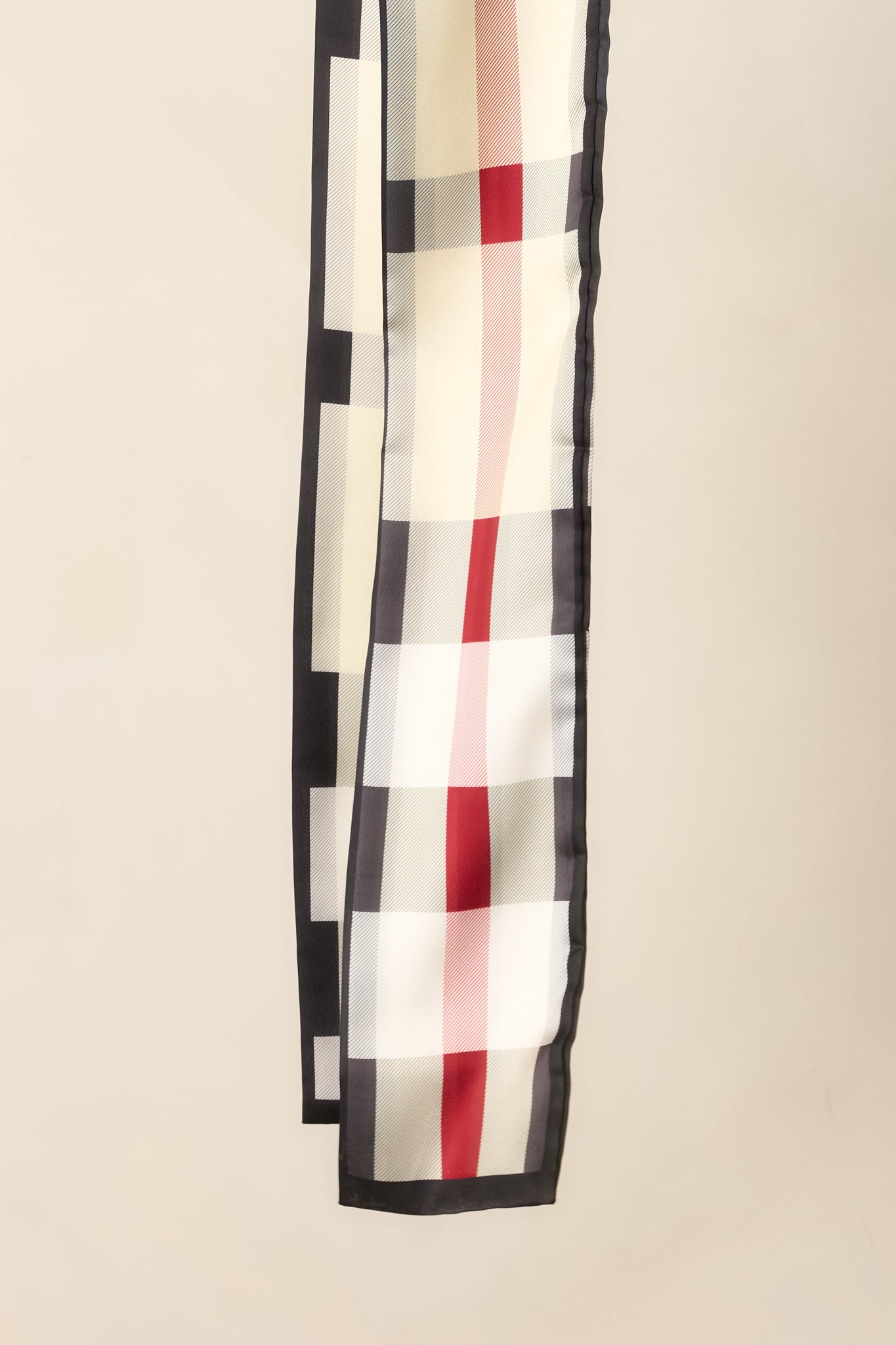 Close view of the slim scarf highlighting its contrasting dark border and neatly finished edges.