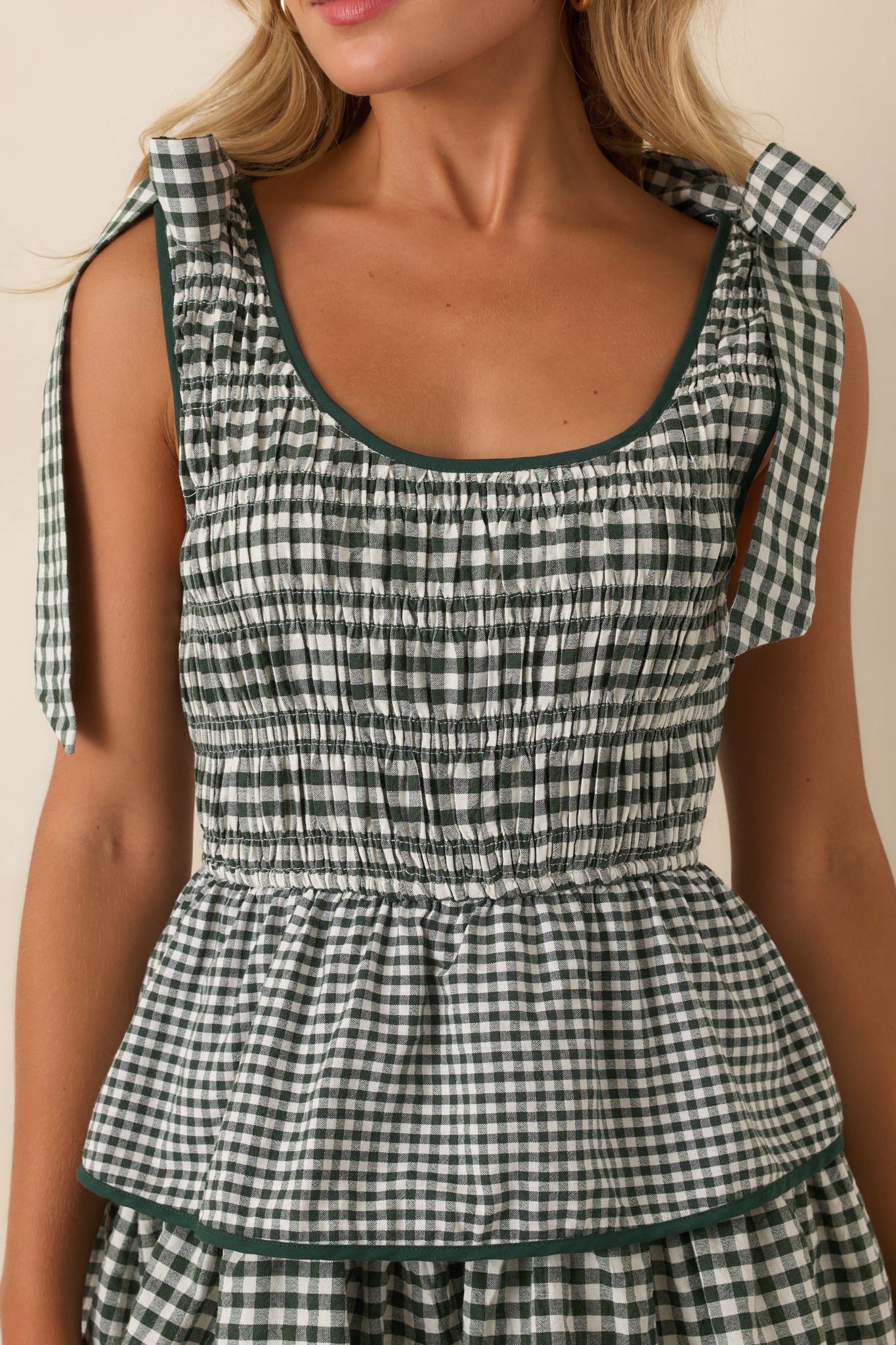 Detailed view of the smocked bodice, scoop neckline, shoulder ties, and coordinating green trim.
