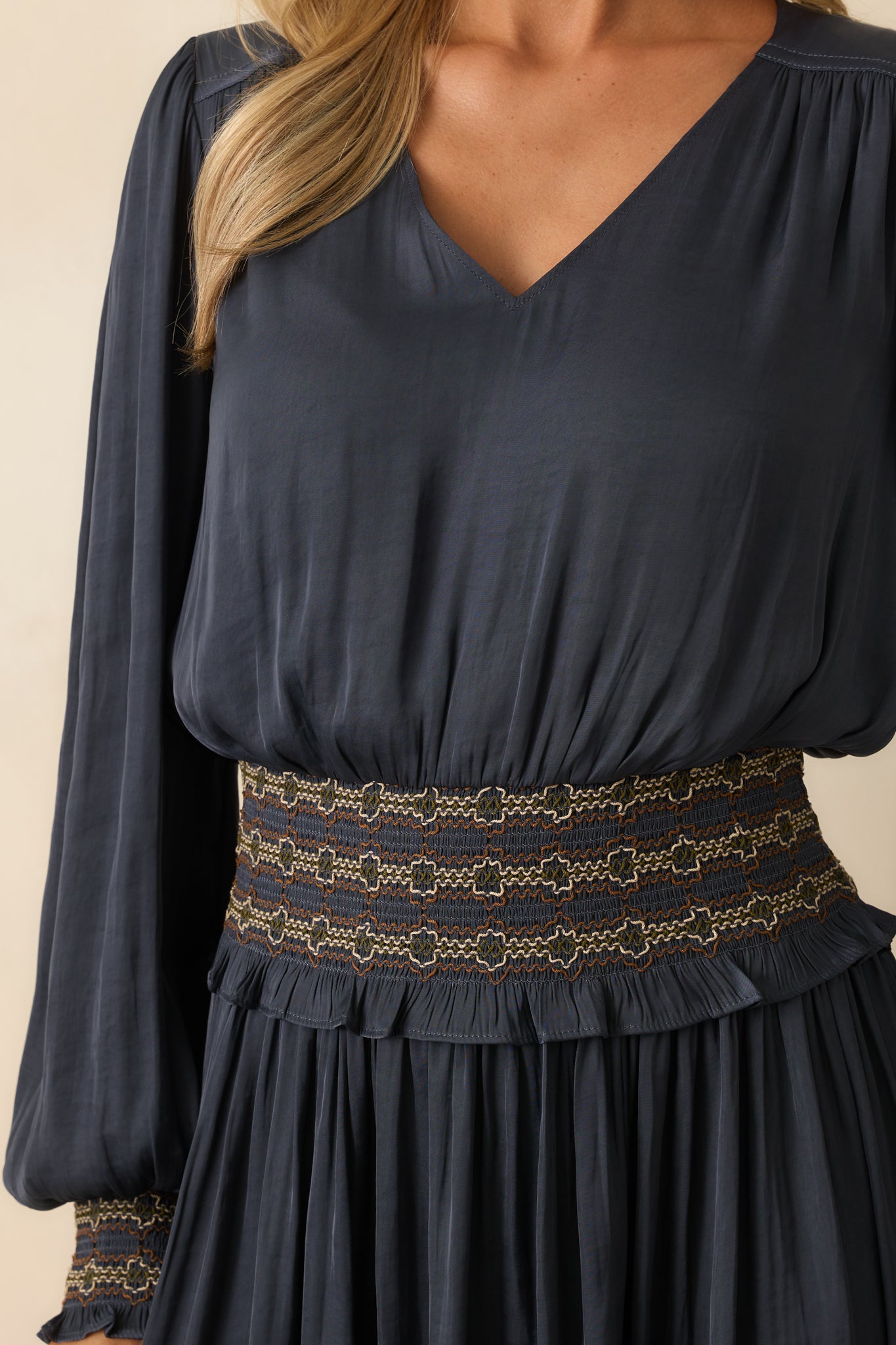 Up-close view of the smocked embroidery showing colorful stitched detail.