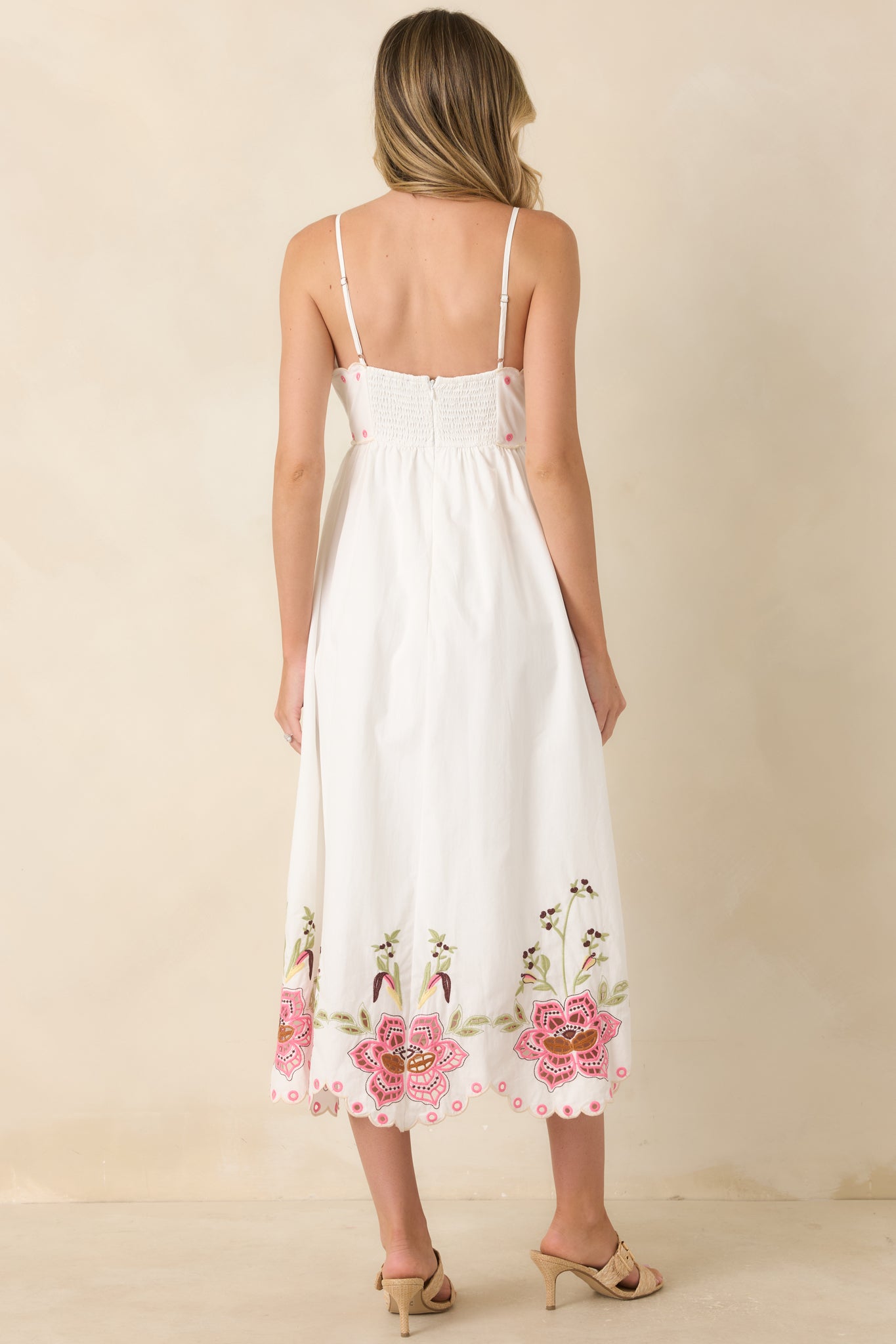 Rear view of the embroidered midi dress featuring adjustable straps, smocked back panel, flowing A-line skirt, and cutwork hem.