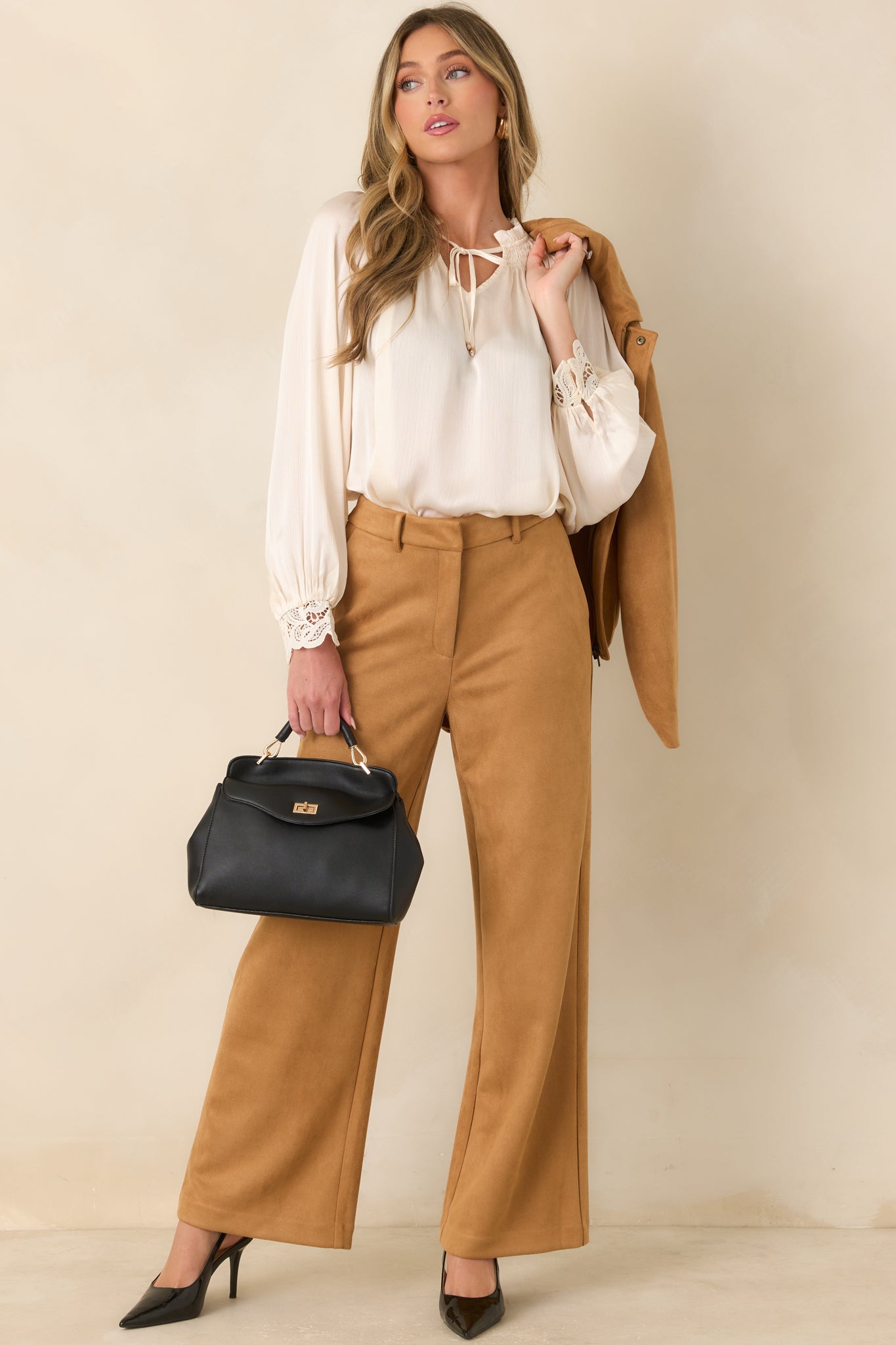 Softly textured blouse showcasing a ruffled smocked neckline, V-shaped split front, elegant balloon sleeves, and detailed lace cuffs.