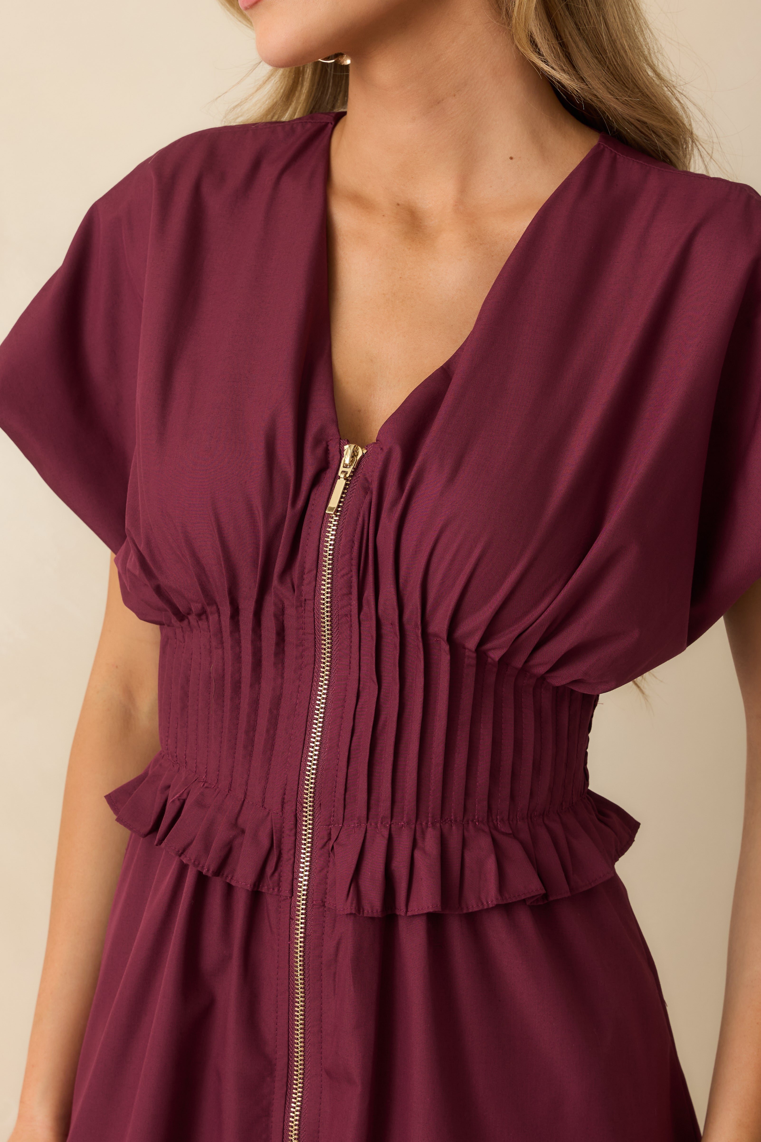 Close-up of the smocked waistband with ruffled trim and subtle woven fabric texture.