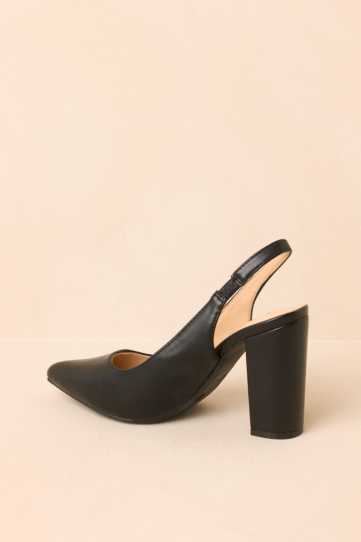 The smooth black finish complements the refined pointed toe and sturdy block heel in this angled view.