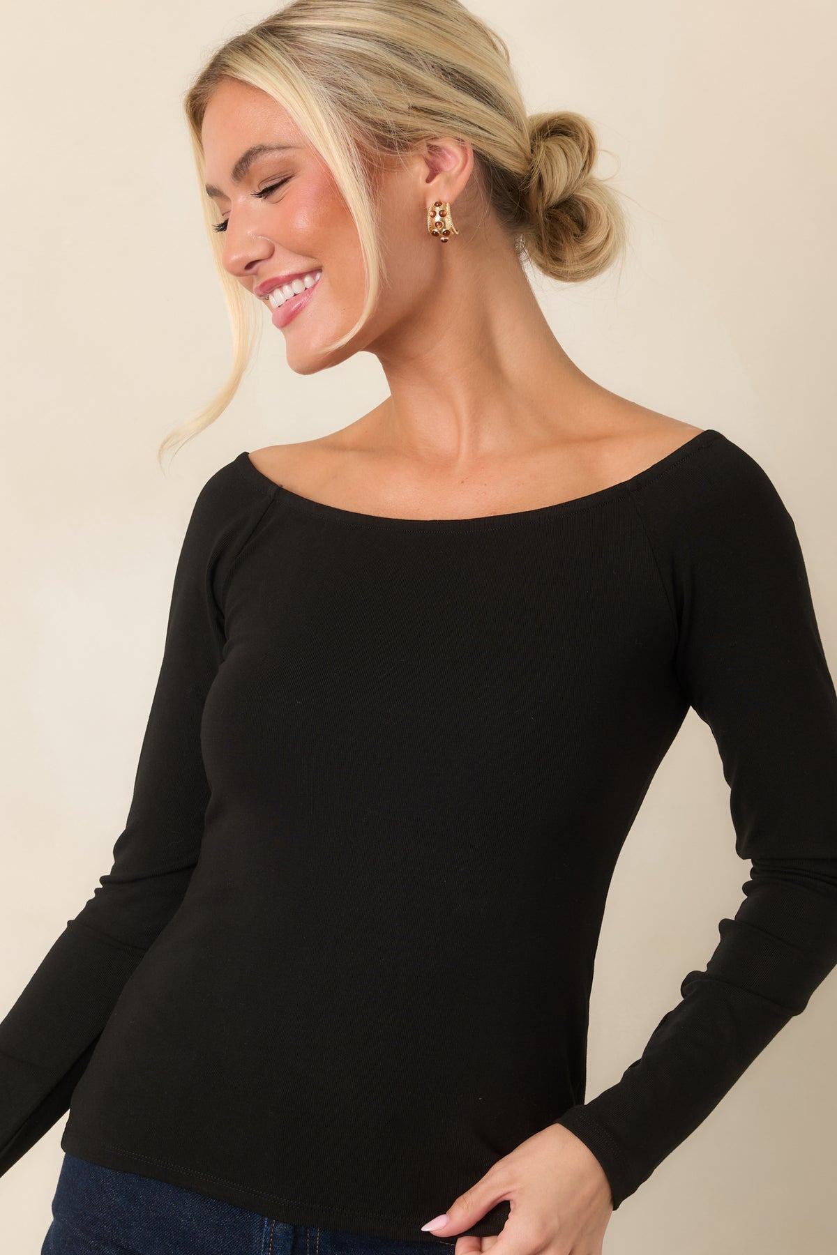 Smooth black top featuring a close-fitting silhouette and softly curved wide neckline.