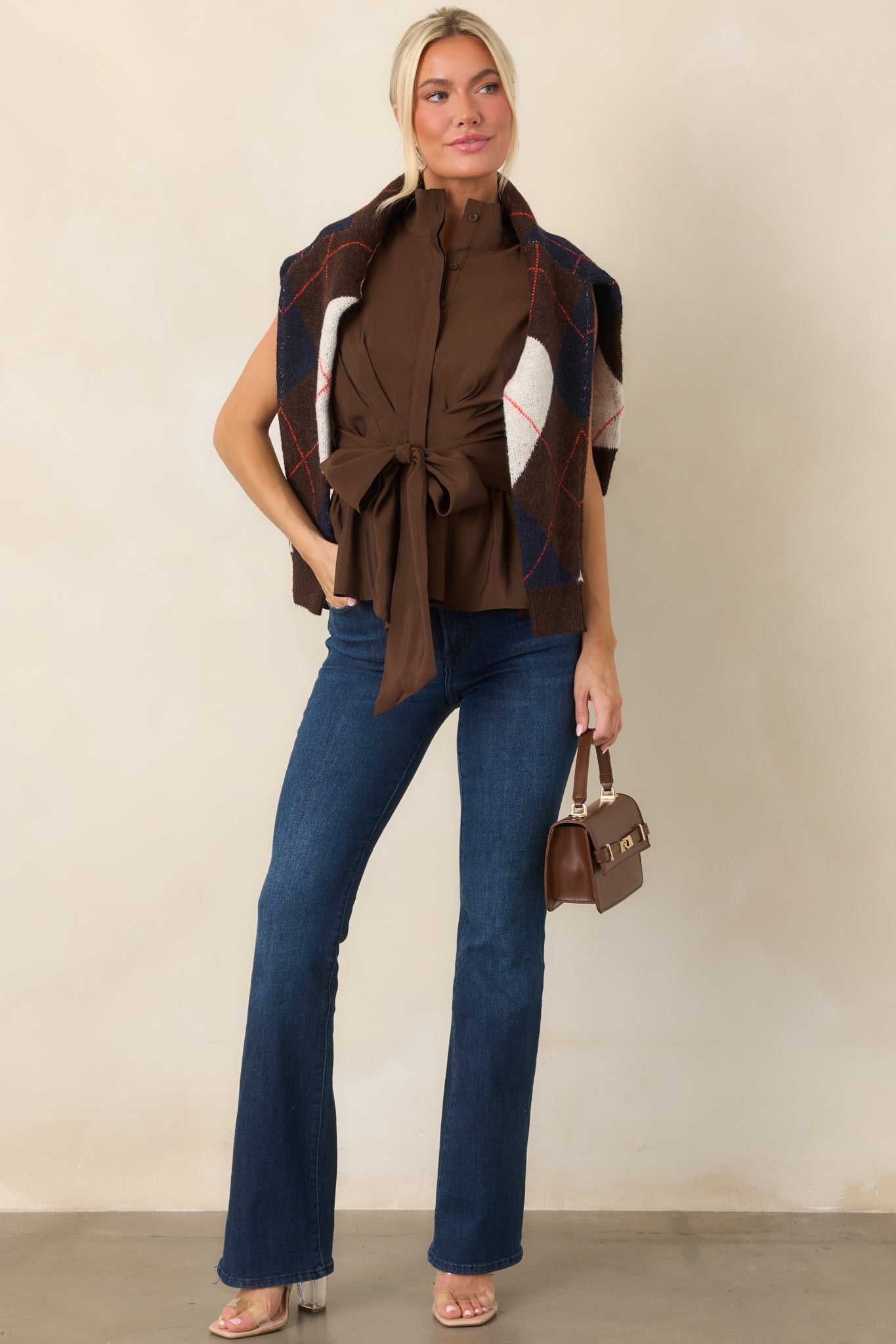 Smooth fabric-blend top featuring a stand collar, partial button placket, gathered waist, oversized front tie, and flattering peplum hem.