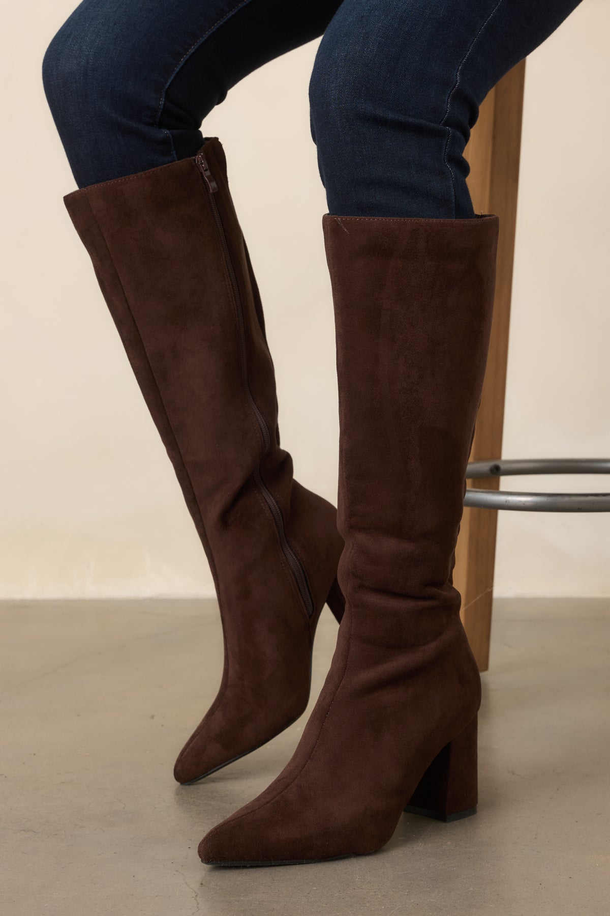 Smooth faux suede boots featuring a streamlined pointed toe and sleek knee-high silhouette.
