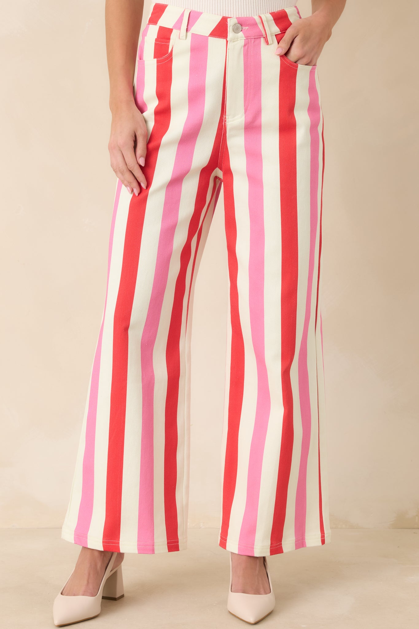 Smooth front closure with zipper and button emphasized on vertically striped wide-leg pants.
