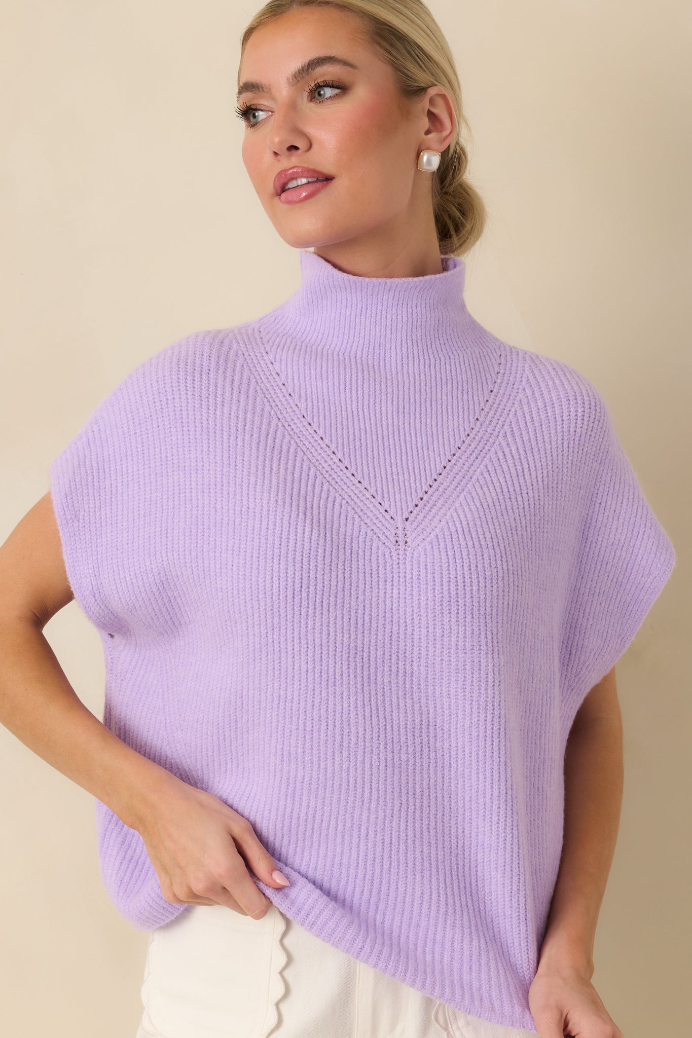 Smooth hemline and soft ribbed fabric of the lavender knit top.