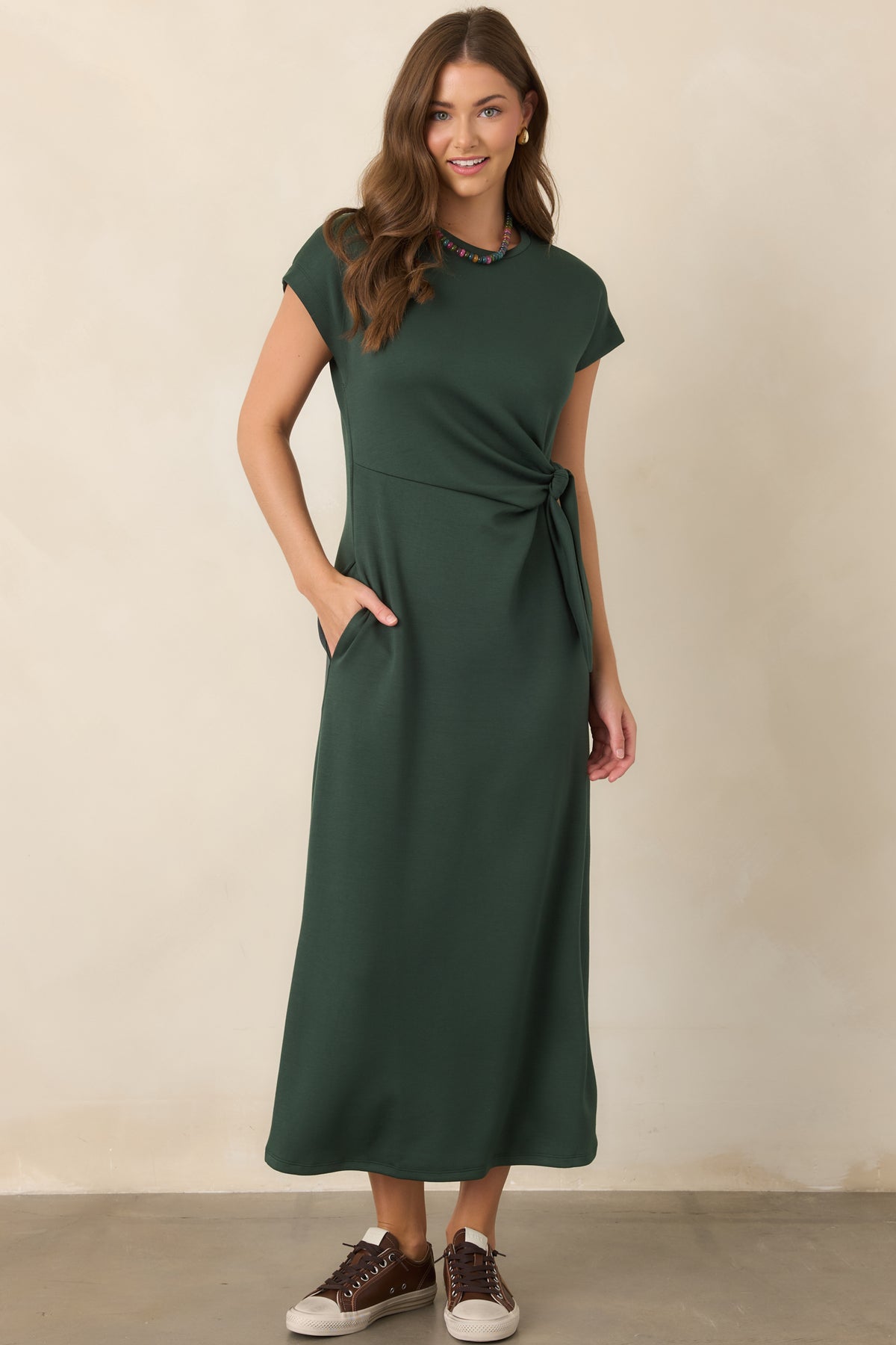 Smooth rayon-blend midi dress showcasing its flexible stretch construction, fluid drape, and softly defined waist with an elegant knot detail.