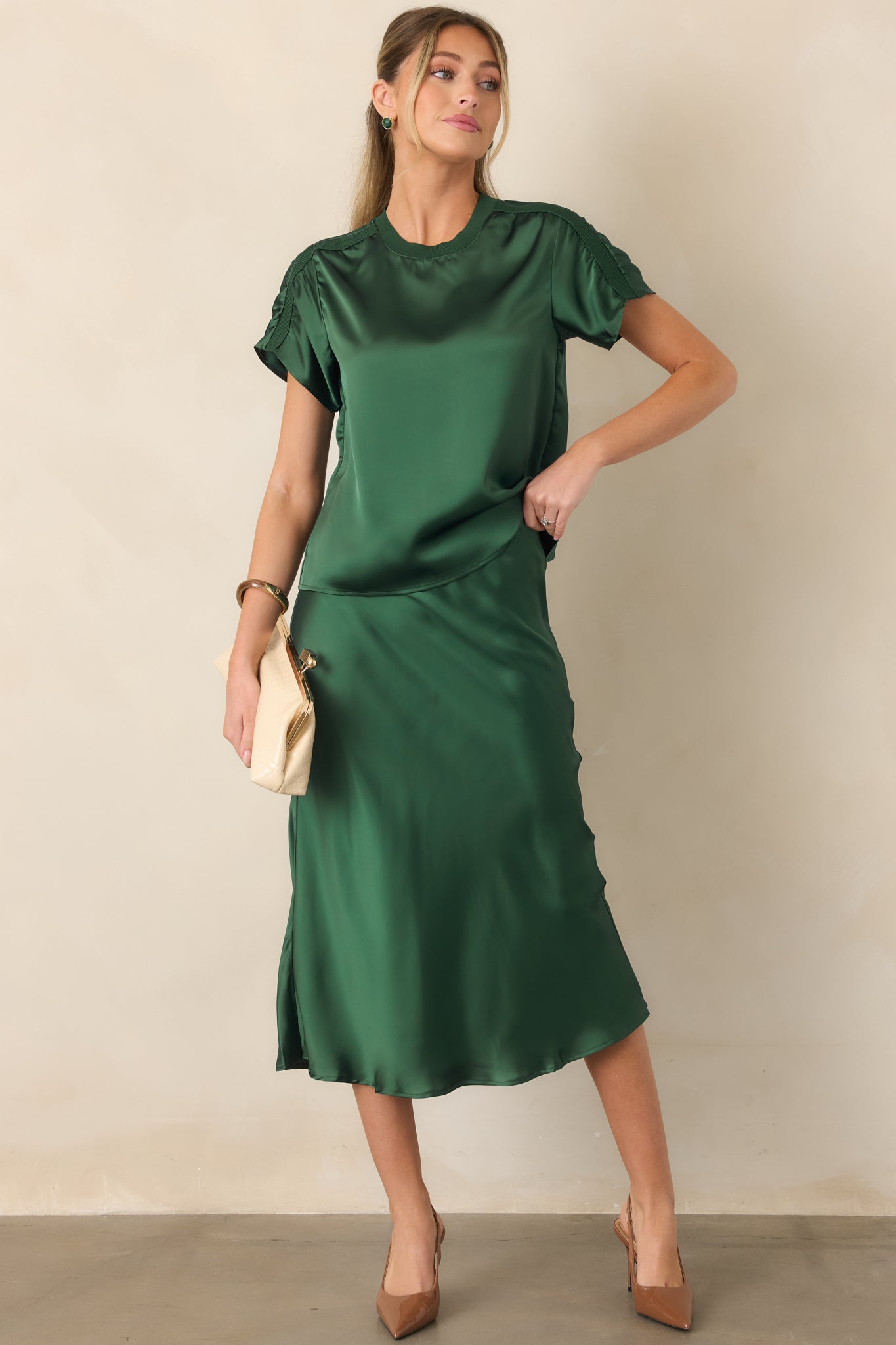 Smooth satin short-sleeve top featuring a soft sheen, round neckline, contrast ribbed trim, and sporty shoulder detailing.