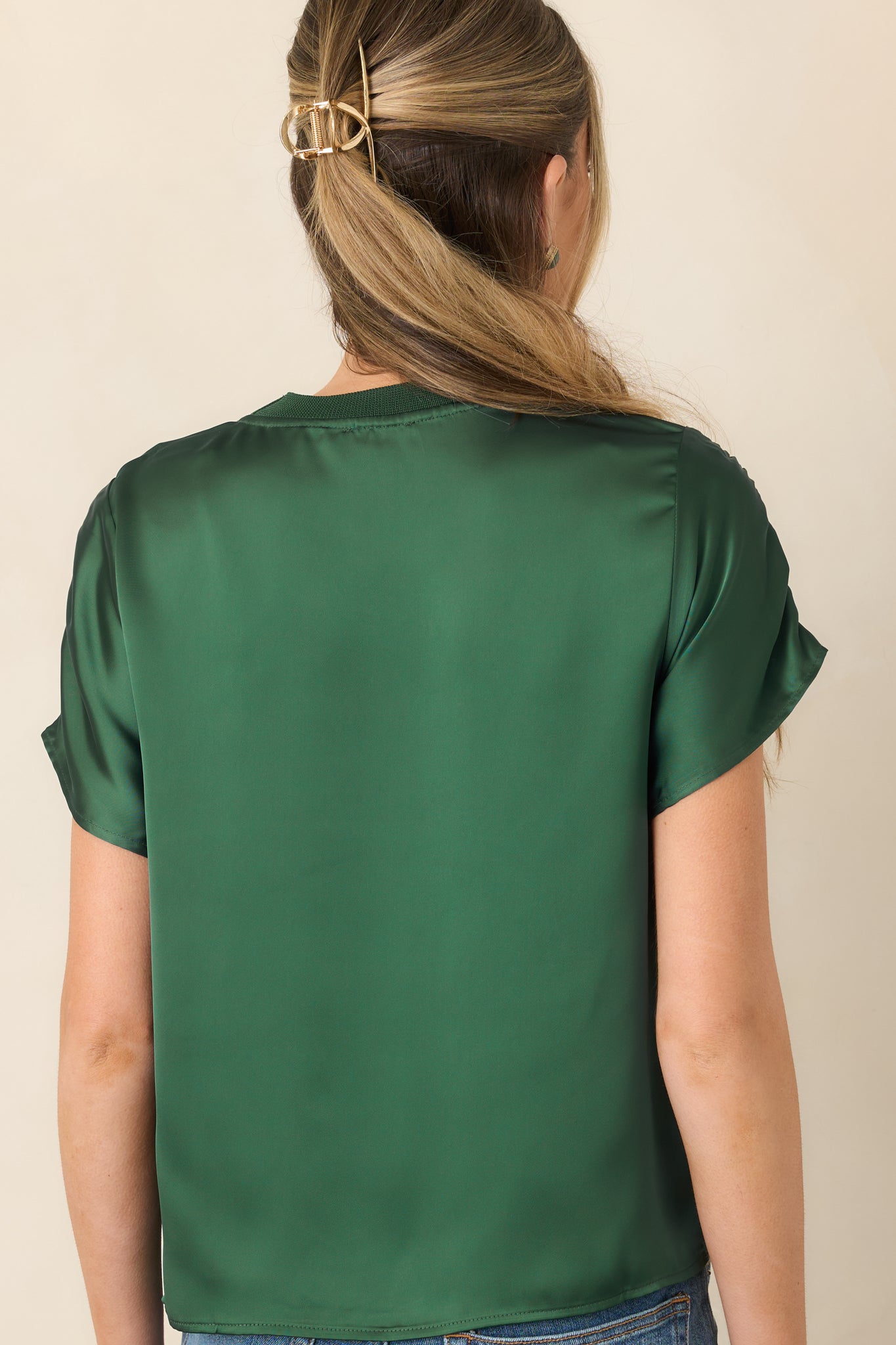 Rear view of the smooth satin top showcasing its short sleeves, rounded neckline, and contrast ribbed shoulder trim.