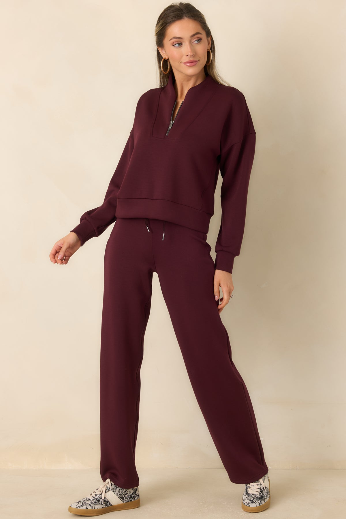 Smooth spacer-fabric top with a half-zip front and wide banded hem.