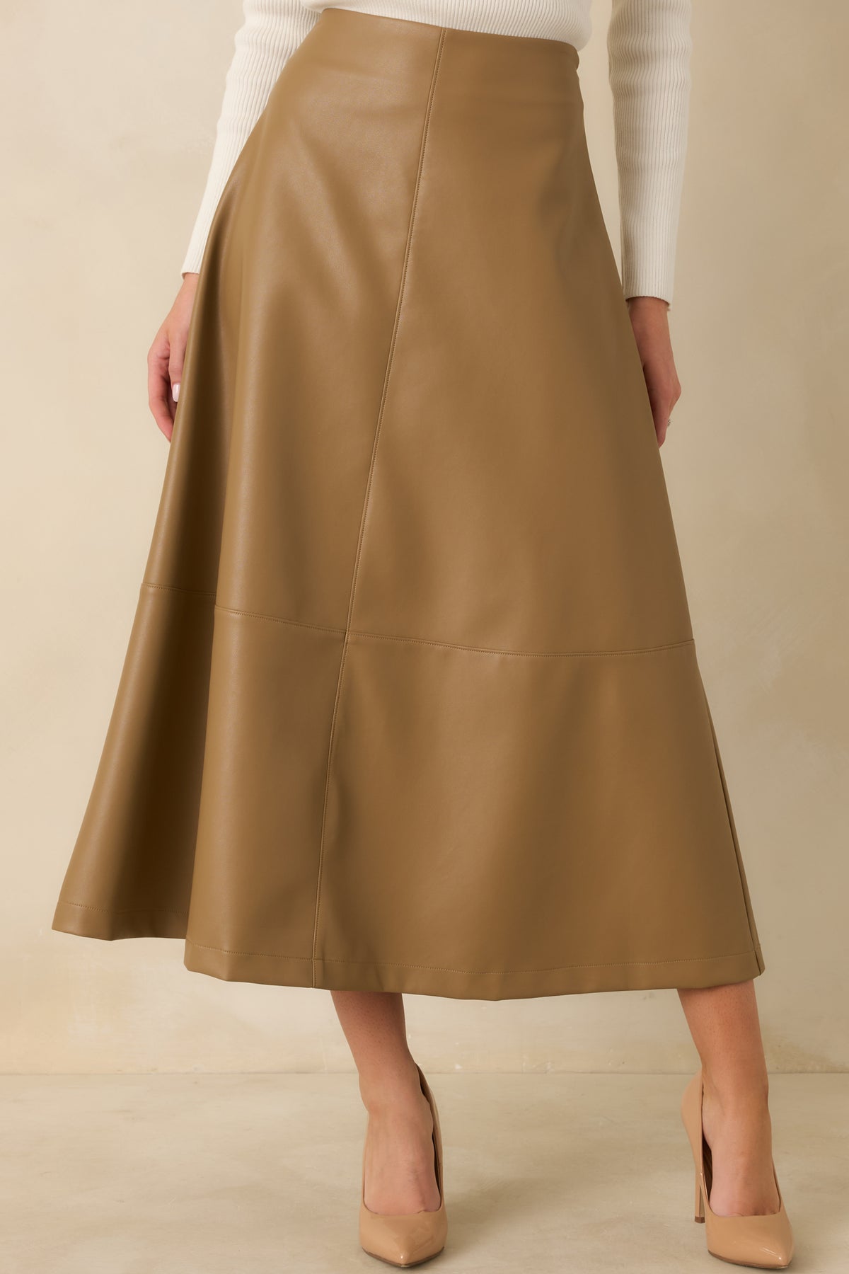 Smooth vegan leather midi skirt featuring the concealed side zipper and clean, polished construction.