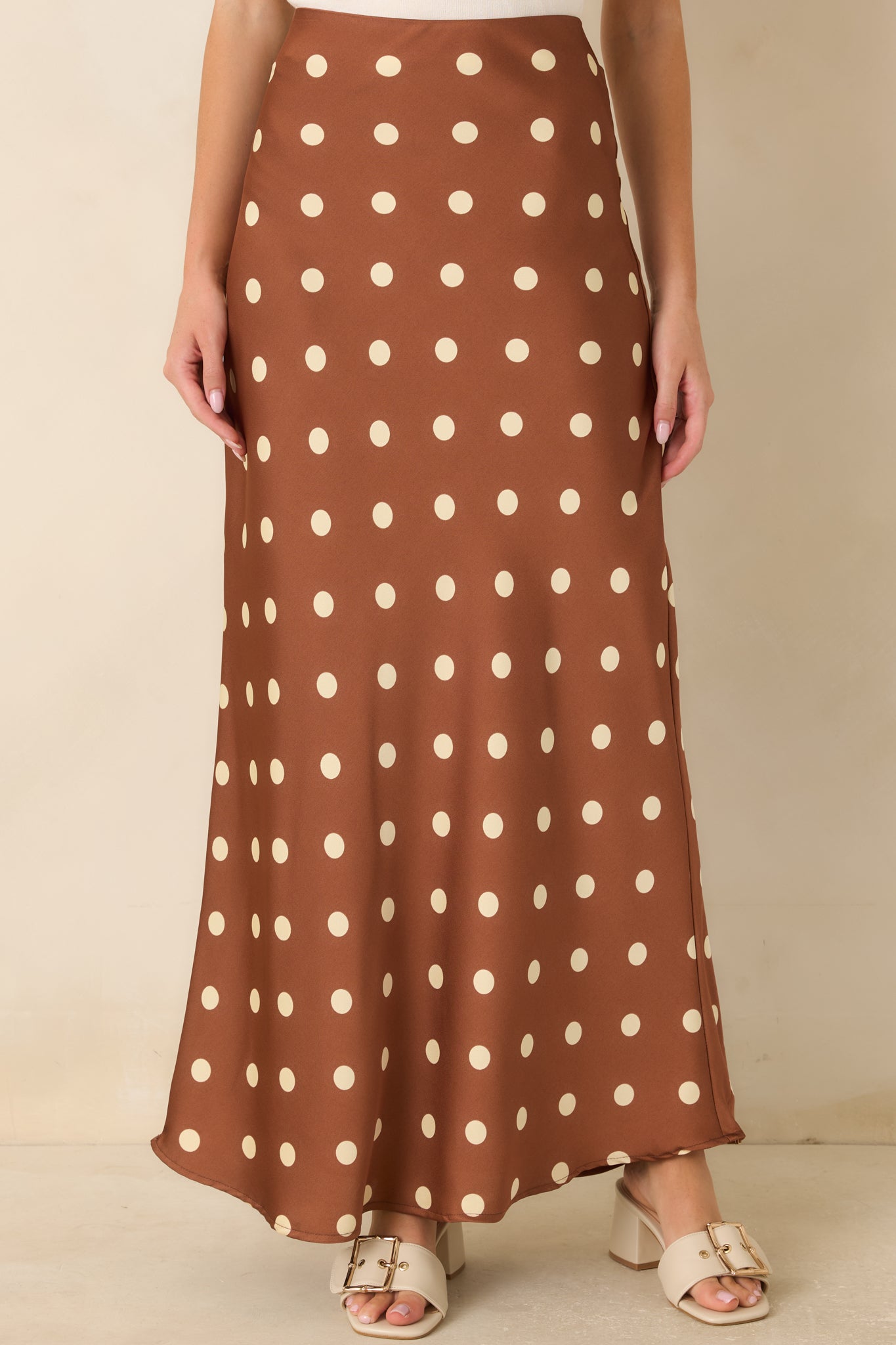 Smooth waistband detail highlights the polished pull-on design of this brown satin polka dot skirt.