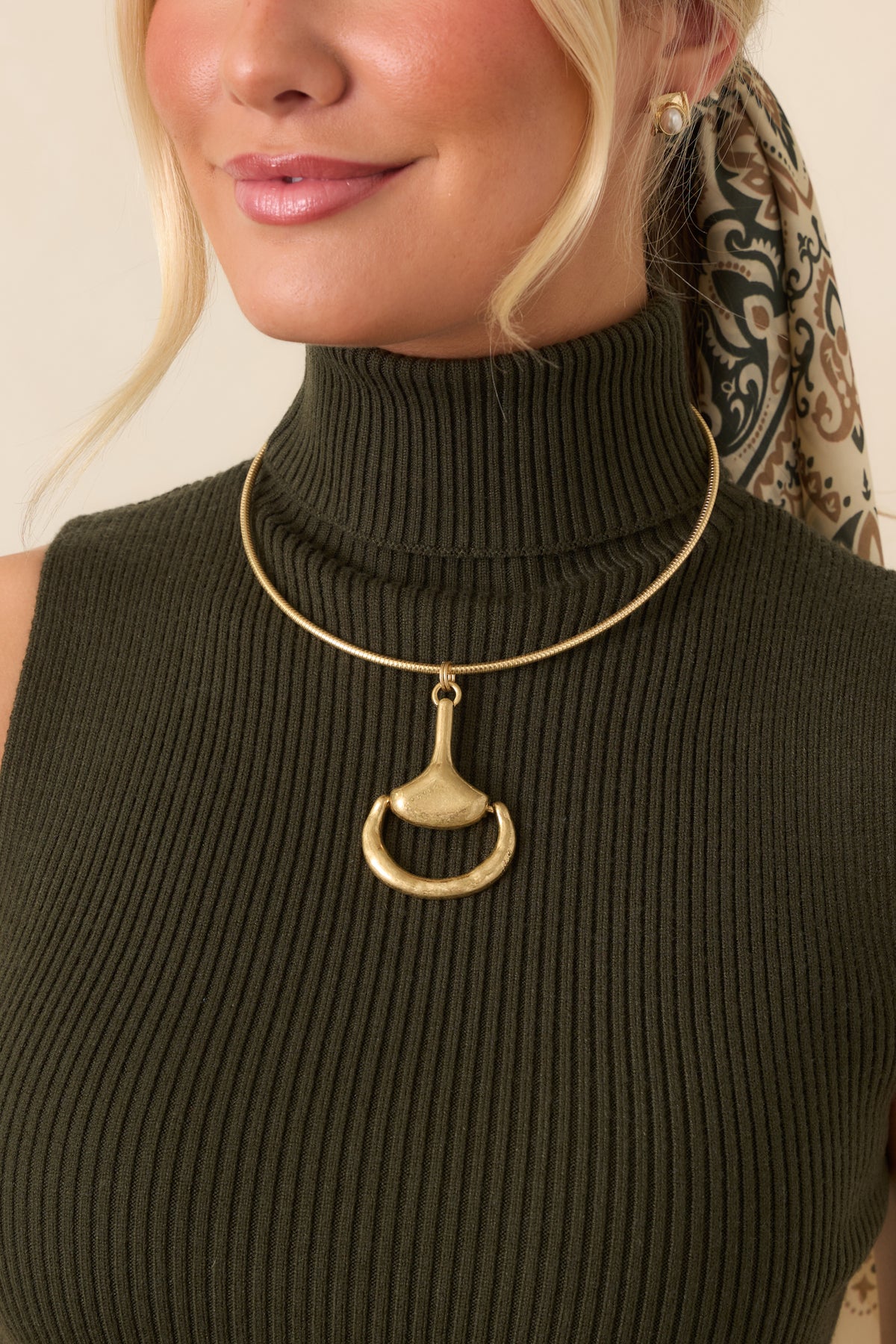 Sleek snake chain necklace featuring a large sculptural horsebit-inspired pendant with a textured organic finish.