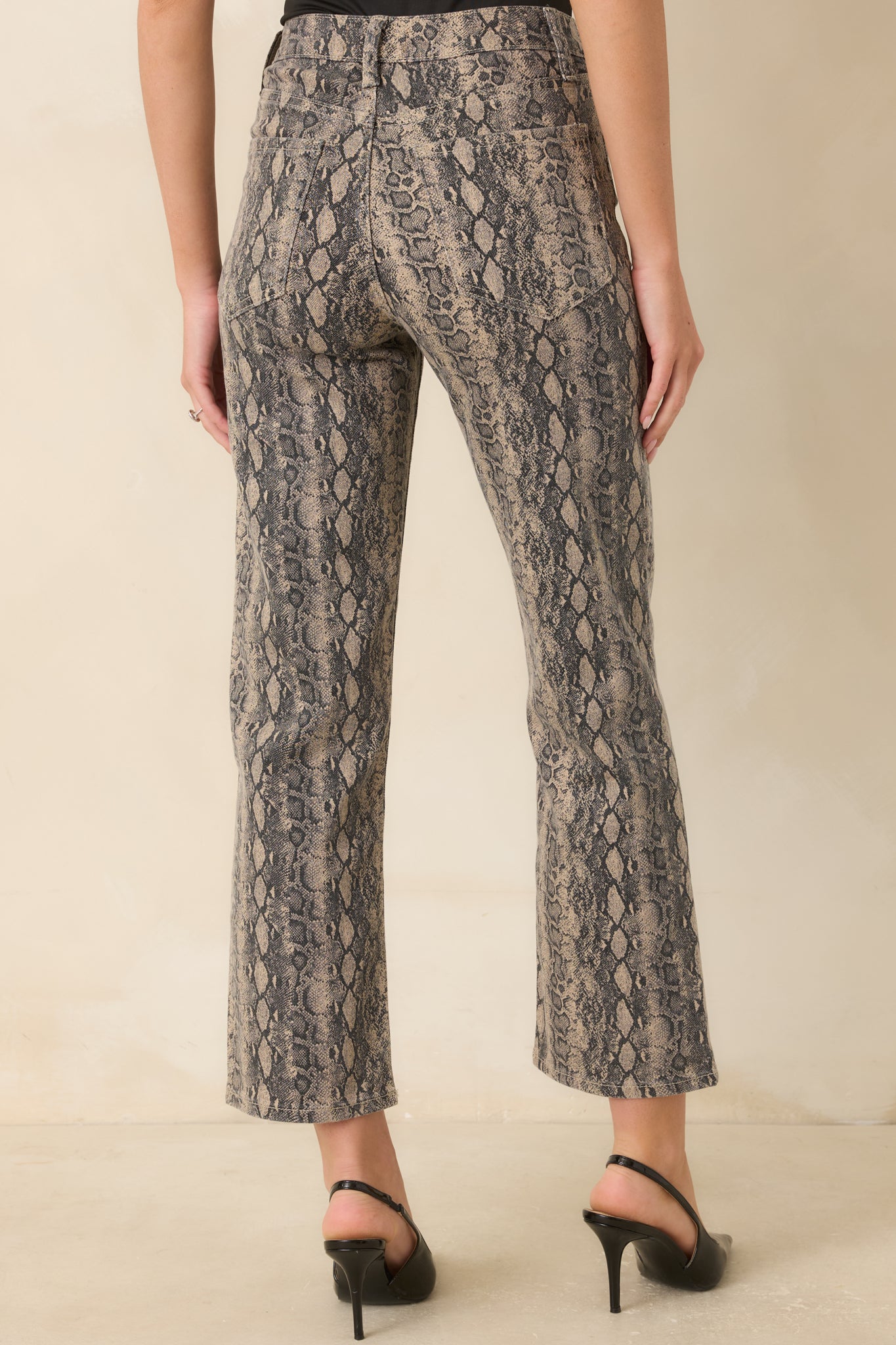 Back view of tan and gray snakeskin jeans featuring back pockets and straight-leg silhouette.