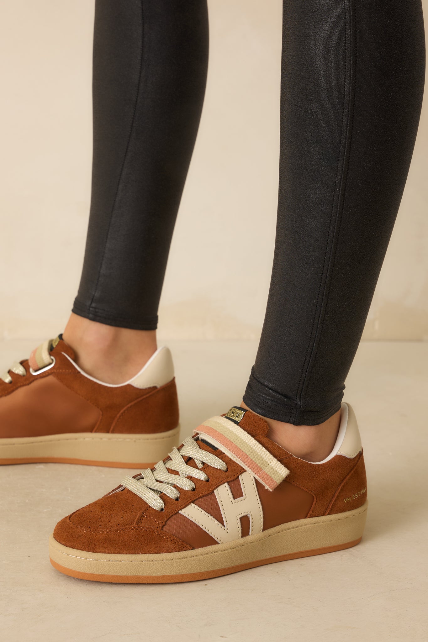 An alternate side angle showing layered leather and suede panels and flat rubber outsole.