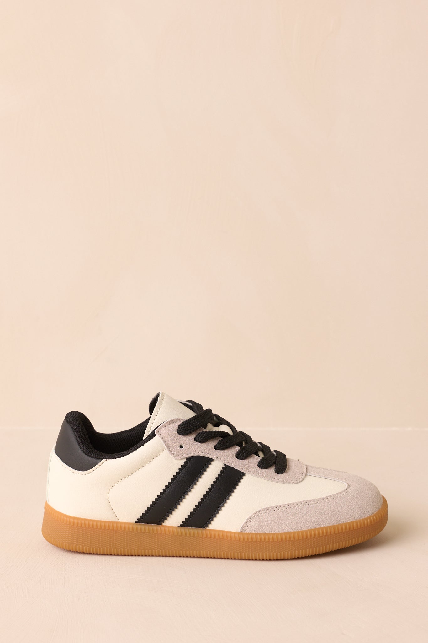 A side profile of the sneakers highlighting the faux leather and faux suede upper and padded collar.