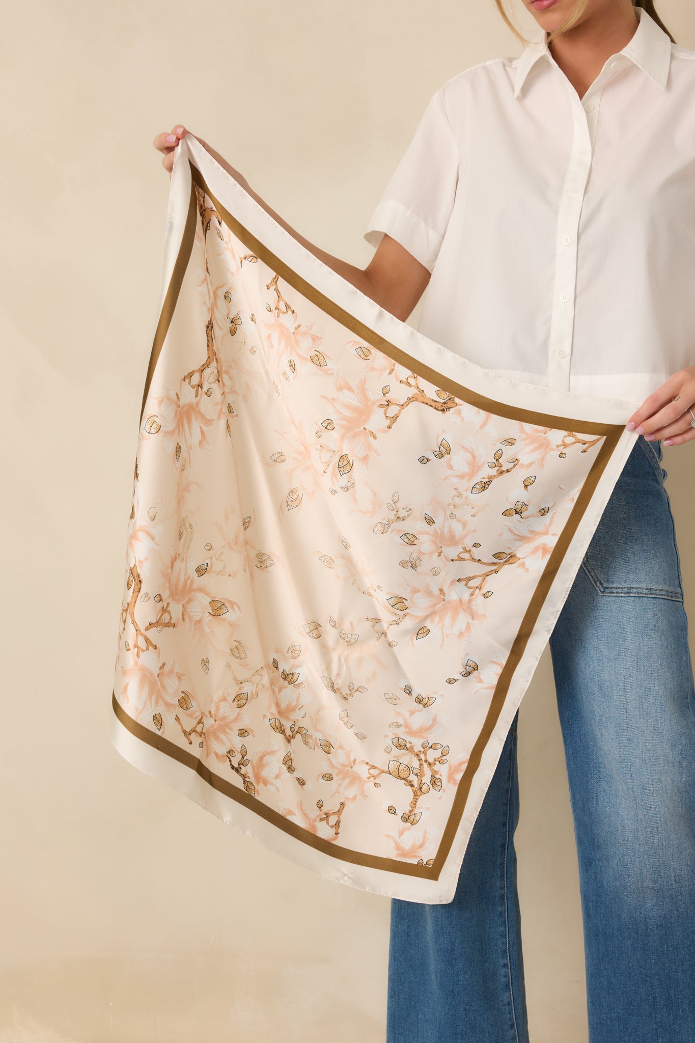 Soft apricot square hair scarf featuring blush peach and warm ivory floral motifs with tan brown leafy accents and an ivory outer border.
