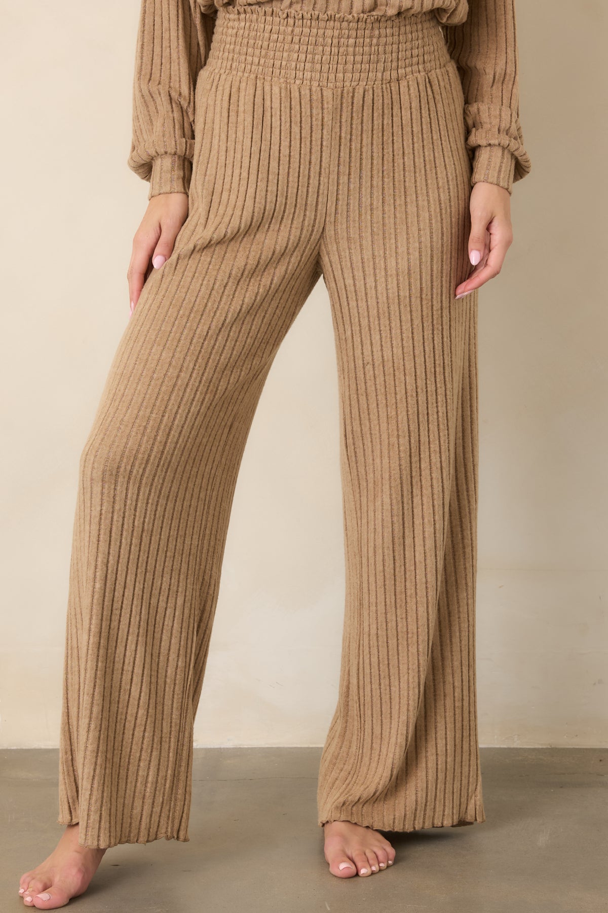 Soft beige pants highlighting the fine rib texture, smocked waistband, and fluid wide-leg silhouette.