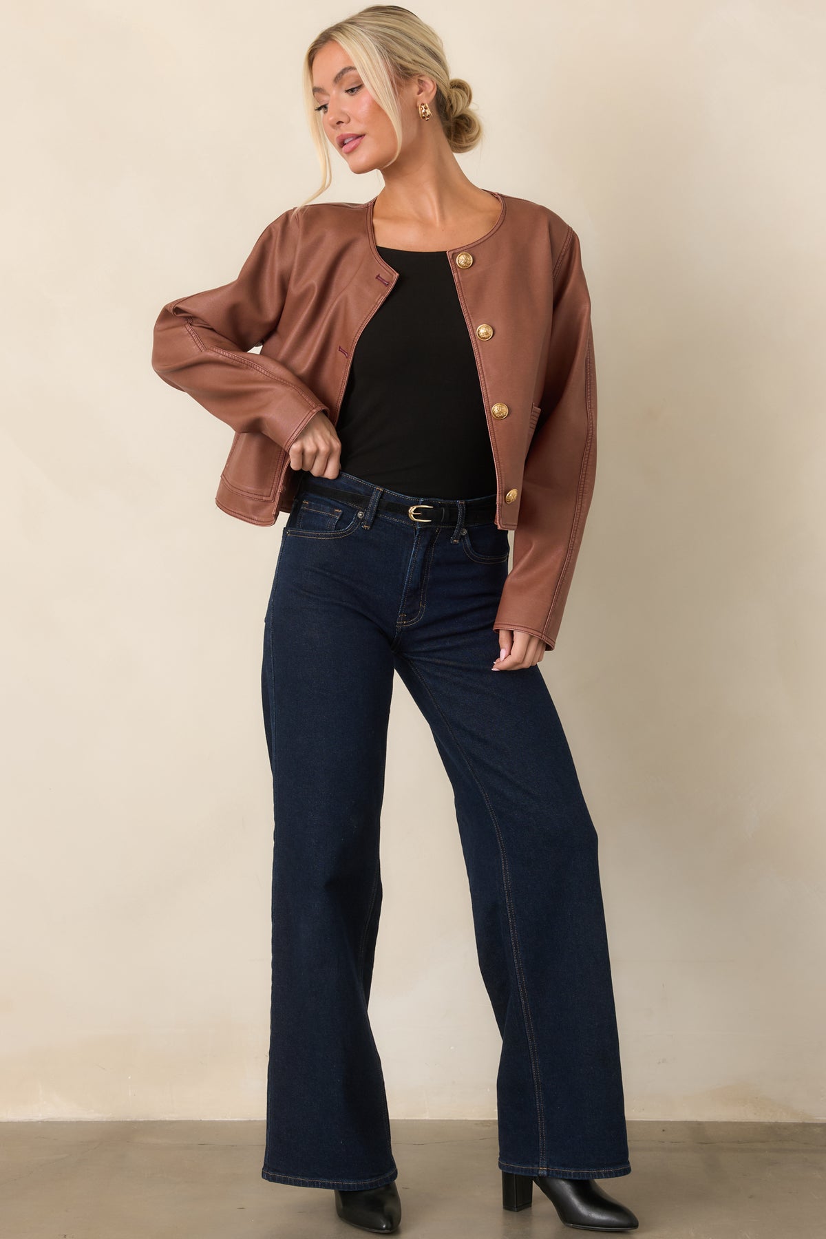 Soft black top featuring a fitted silhouette and wide boat neckline that frames the collarbone.