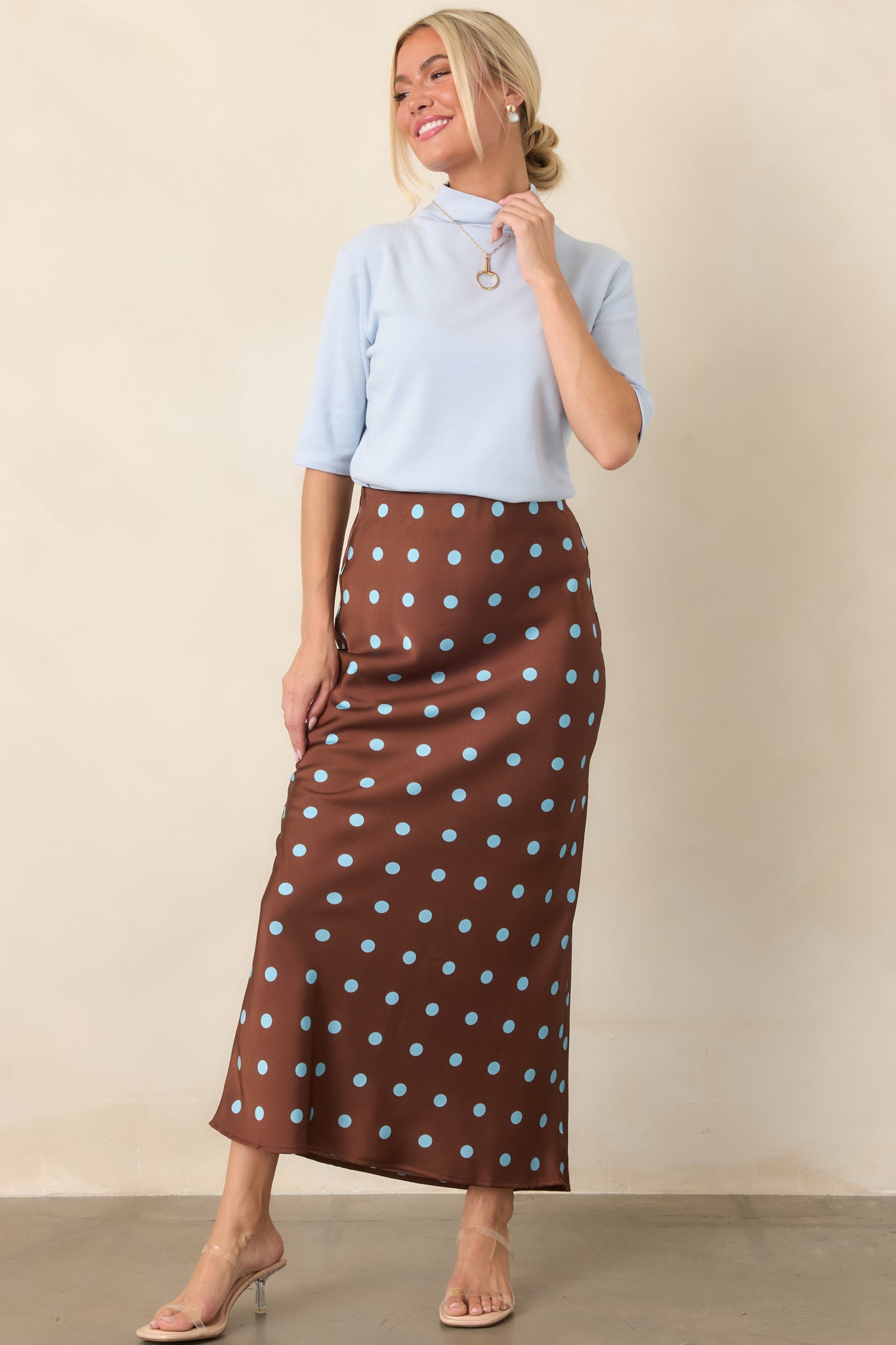 Soft blue top showcasing a smooth knit finish, streamlined shape, and polished mock-neck design with short sleeves.