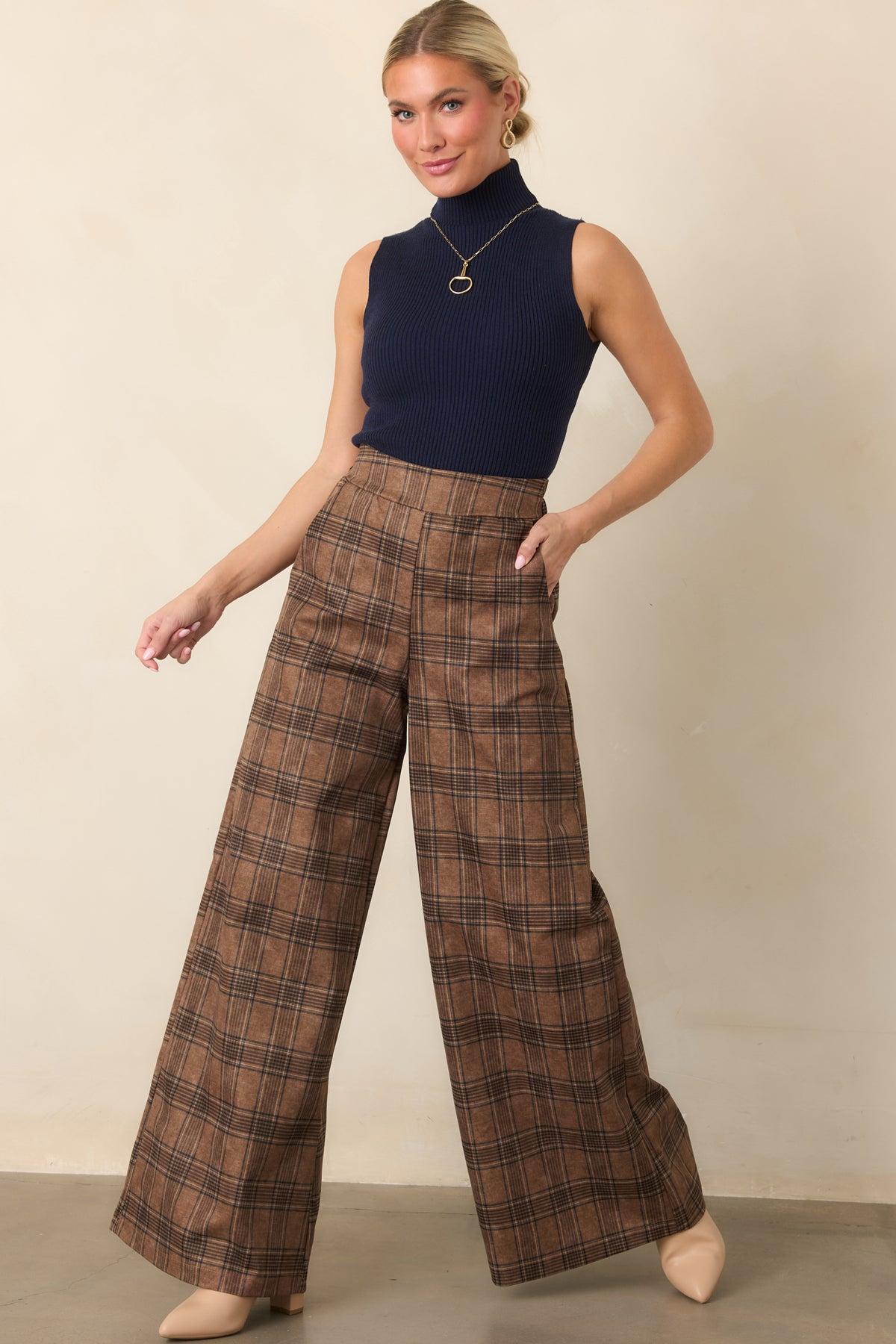 Softly structured brown plaid pants with a high-rise waist, relaxed wide-leg shape, and smooth draping fabric.