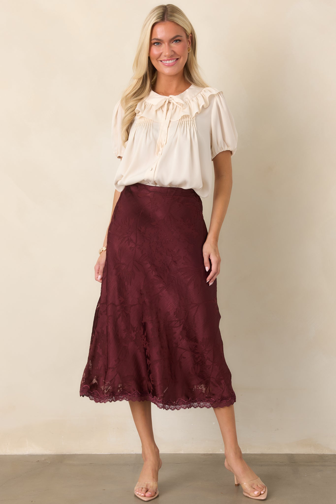Soft champagne top showcasing its relaxed cropped fit, voluminous puff sleeves, elasticized cuffs, and gently draped shape.