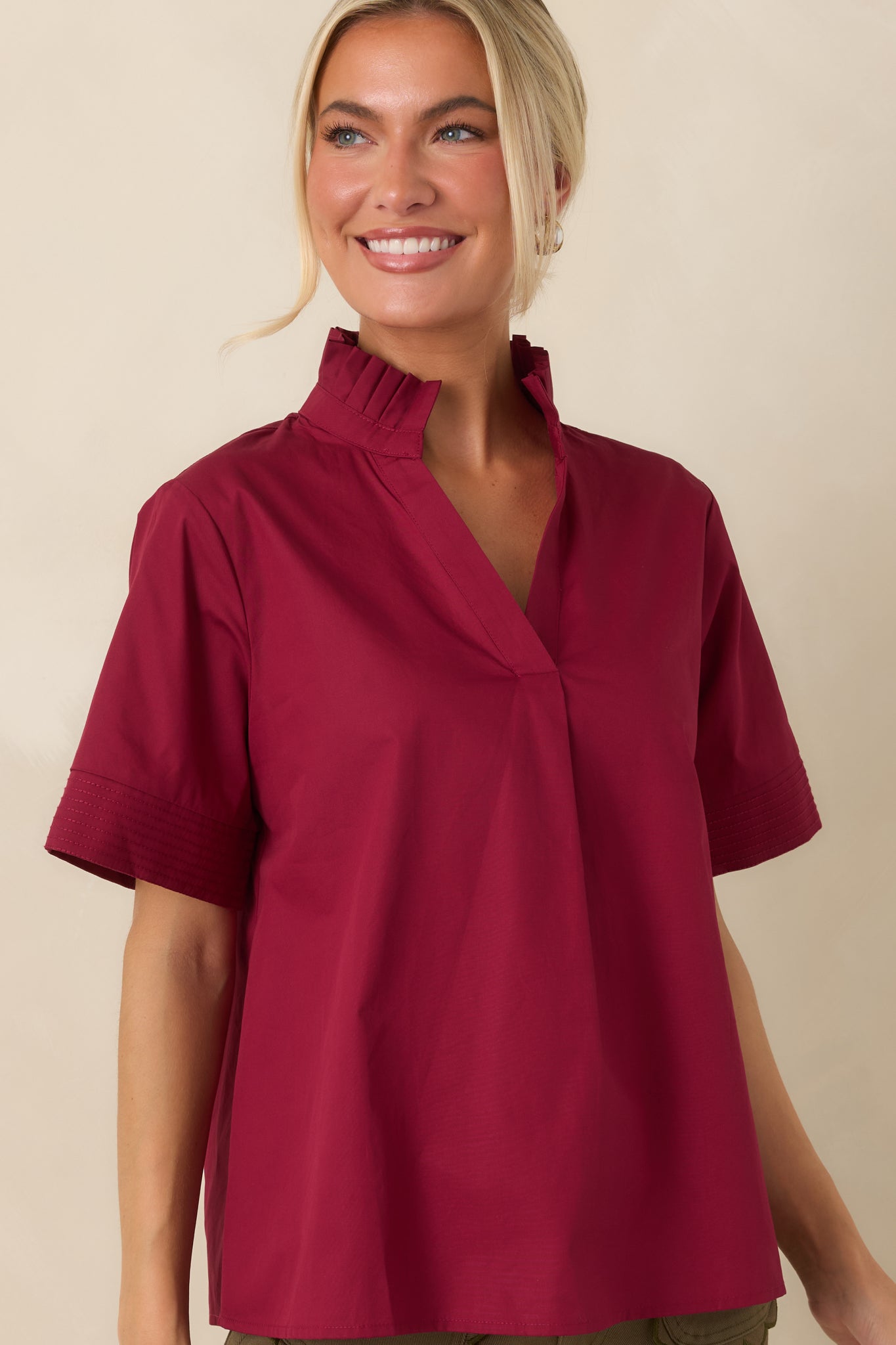 Soft cotton fabric close-up showcasing the structured ruffle trim and polished construction of the top.