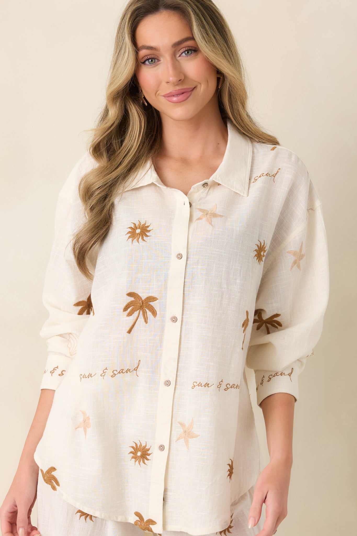 Soft cotton top with collared neckline and structured sleeve cuffs.