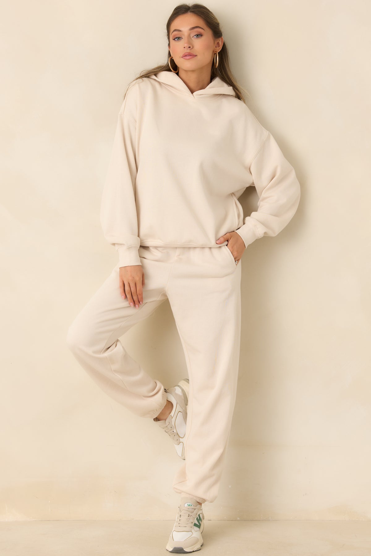 Soft cream pullover hoodie with dropped shoulders and a relaxed silhouette.